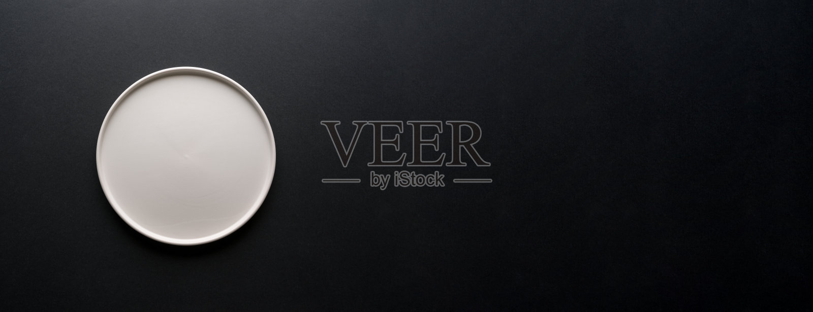 黑色背景上的空白陶瓷白盘的俯视图照片摄影图片