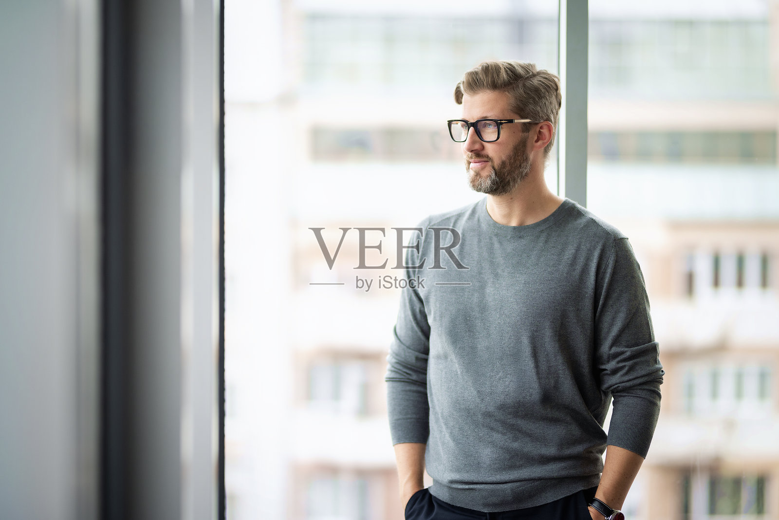 商务人士站在现代办公室内俯瞰城市景观照片摄影图片