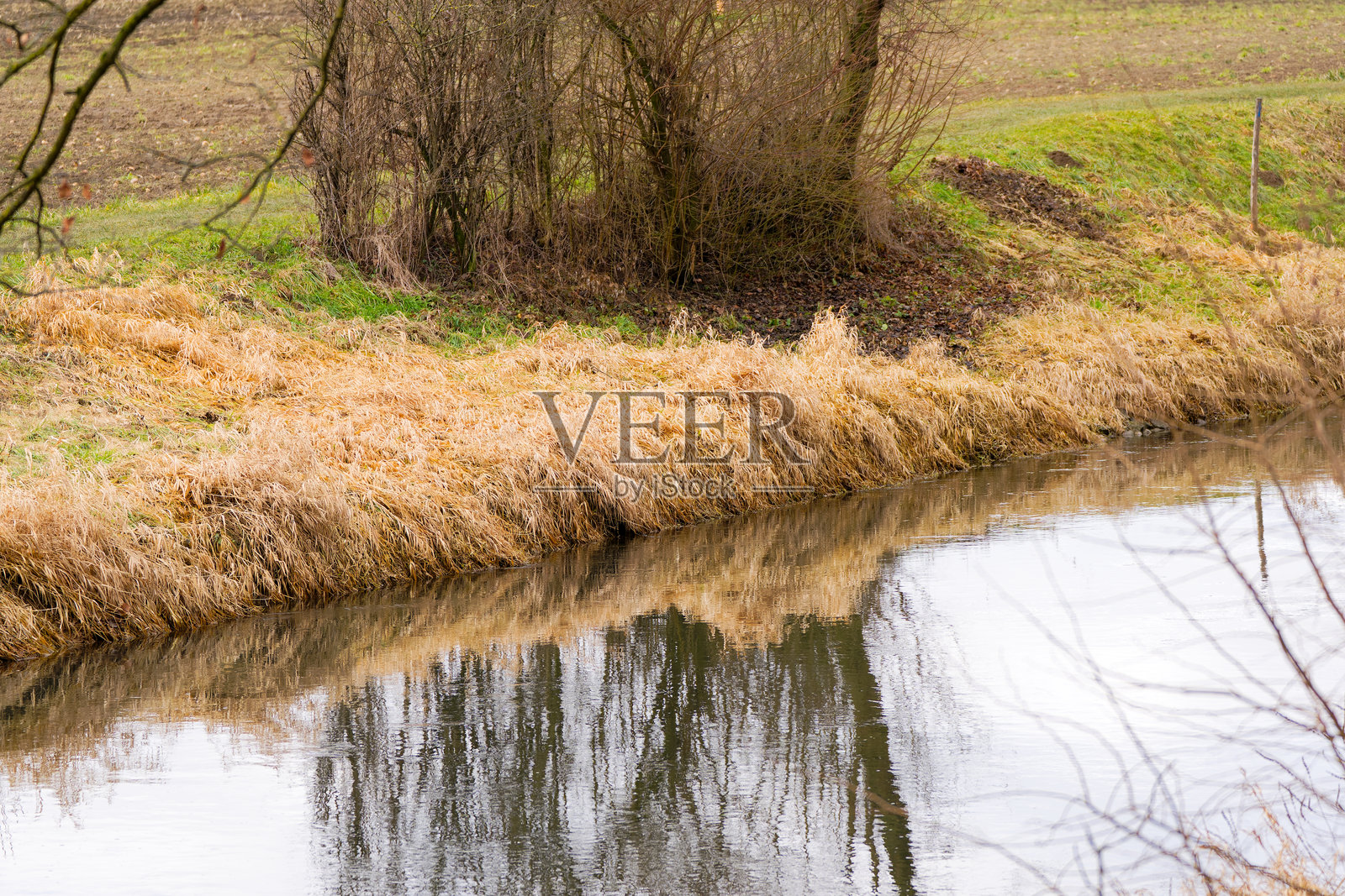 高角度俯瞰瑞士苏黎世克洛滕机场的格拉特河，河中有芦苇和树枝的倒影，冬日景象。照片摄影图片
