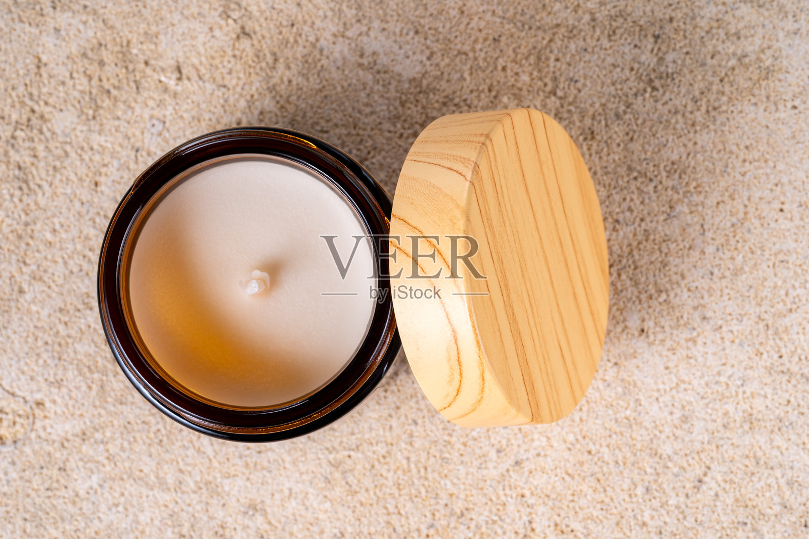 石材背景上，玻璃罐中装有蜡质大豆香氛蜡烛，配有竹制盖子。营造自然舒适的放松和水疗氛围。照片摄影图片