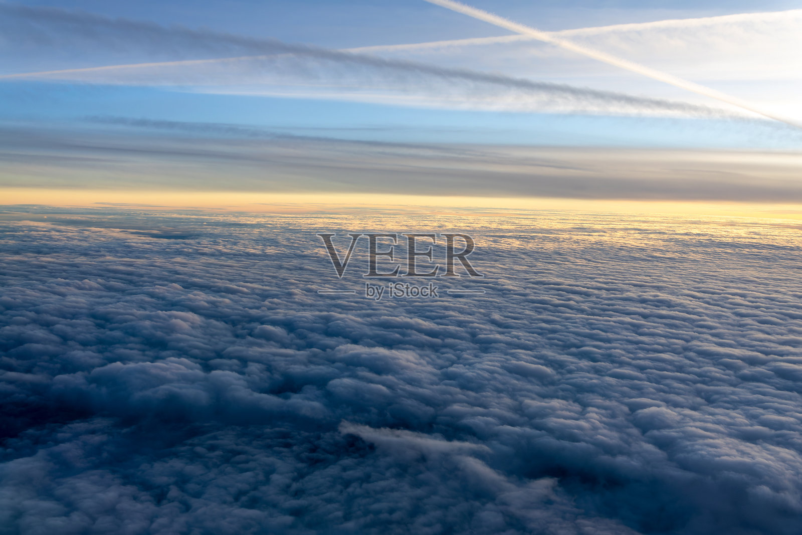 日落时分从飞机舷窗俯瞰的云海照片摄影图片