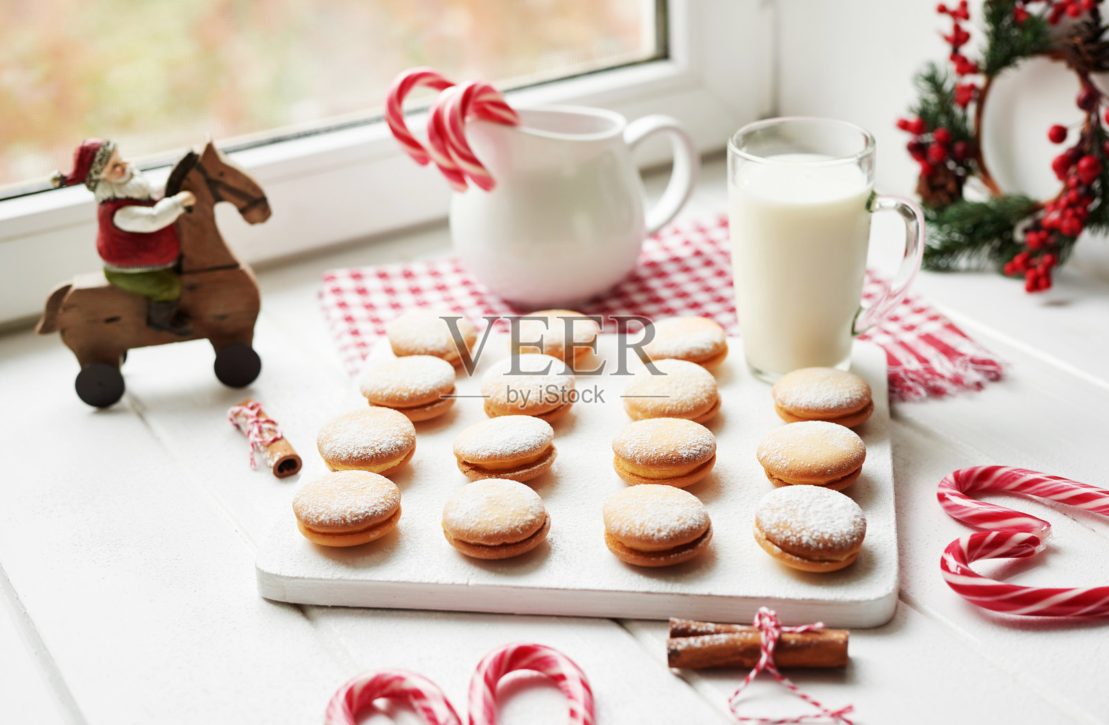 圣诞蛋糕和甜点摆放在桌子上。背景是带灯光的圣诞装饰。新年快乐！圣诞贺卡。冬季卡片模板。圣诞概念。节日横幅。圣诞节盛宴。照片摄影图片