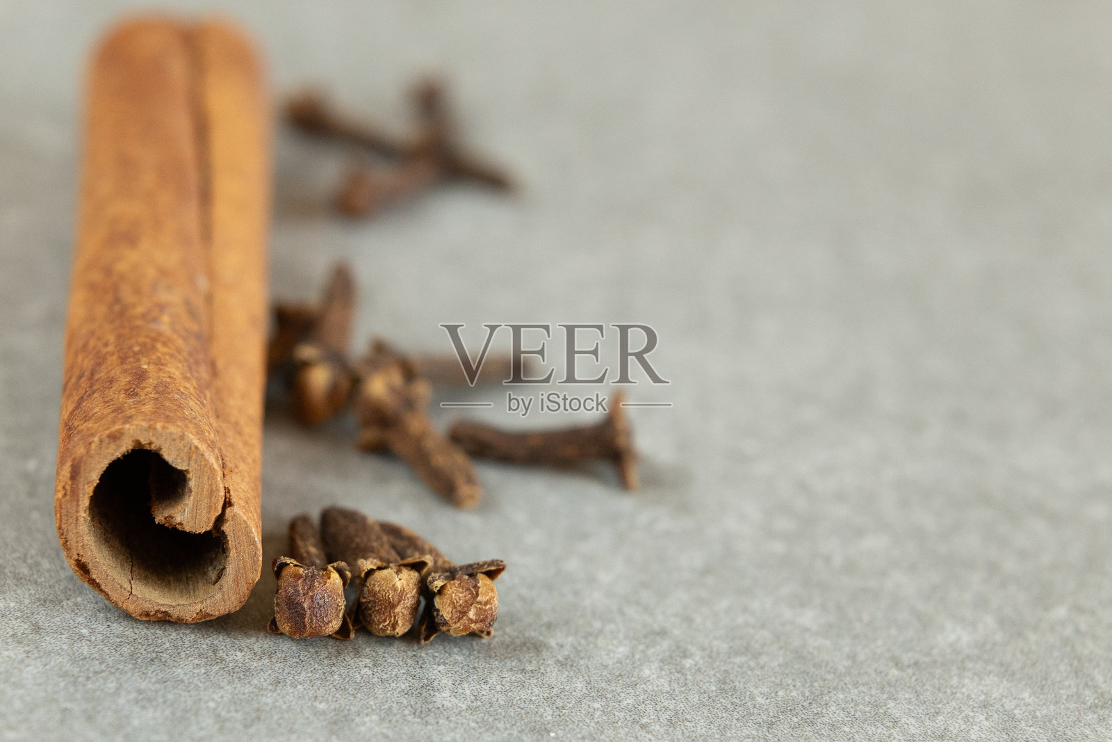 肉桂棒和丁香的特写，背景为灰色照片摄影图片