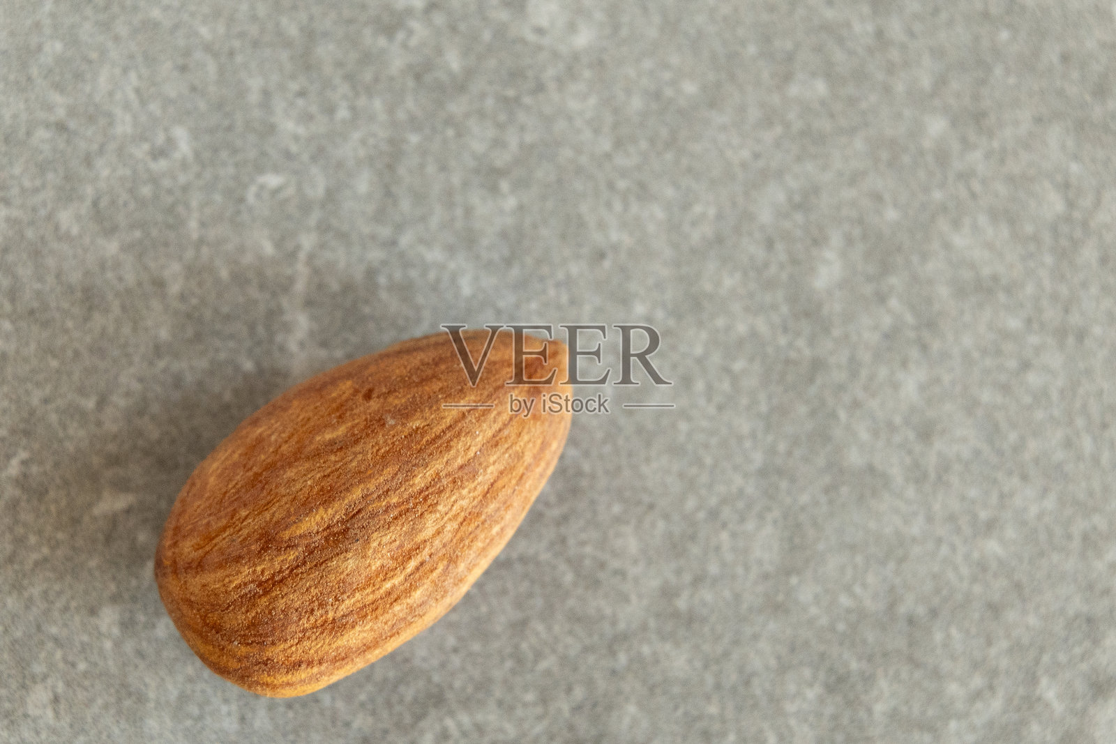 杏仁特写在灰色表面上。照片摄影图片