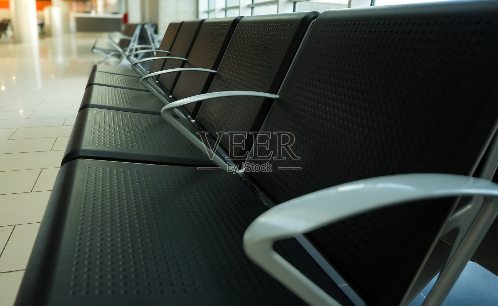 机场航站楼候机区的空座位，靠近登机口。象征着航班延误、候机室中转和现代交通枢纽舒适感的旅行概念。照片摄影图片