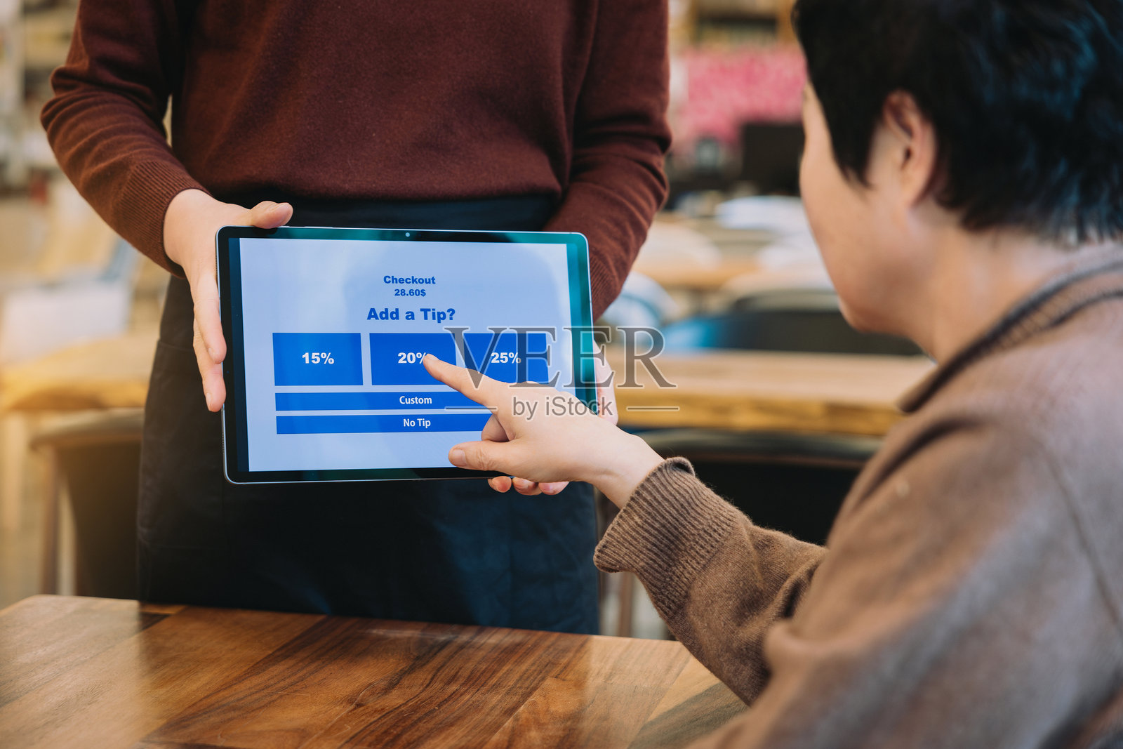 咖啡馆的消费小费支付，顾客用手触碰支付小费照片摄影图片