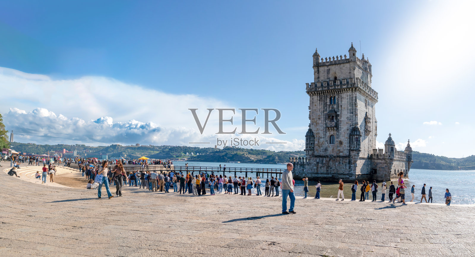 在阳光明媚的日子里，著名的贝伦塔在塔霍河上的全景，许多人在博物馆入口排队。照片摄影图片