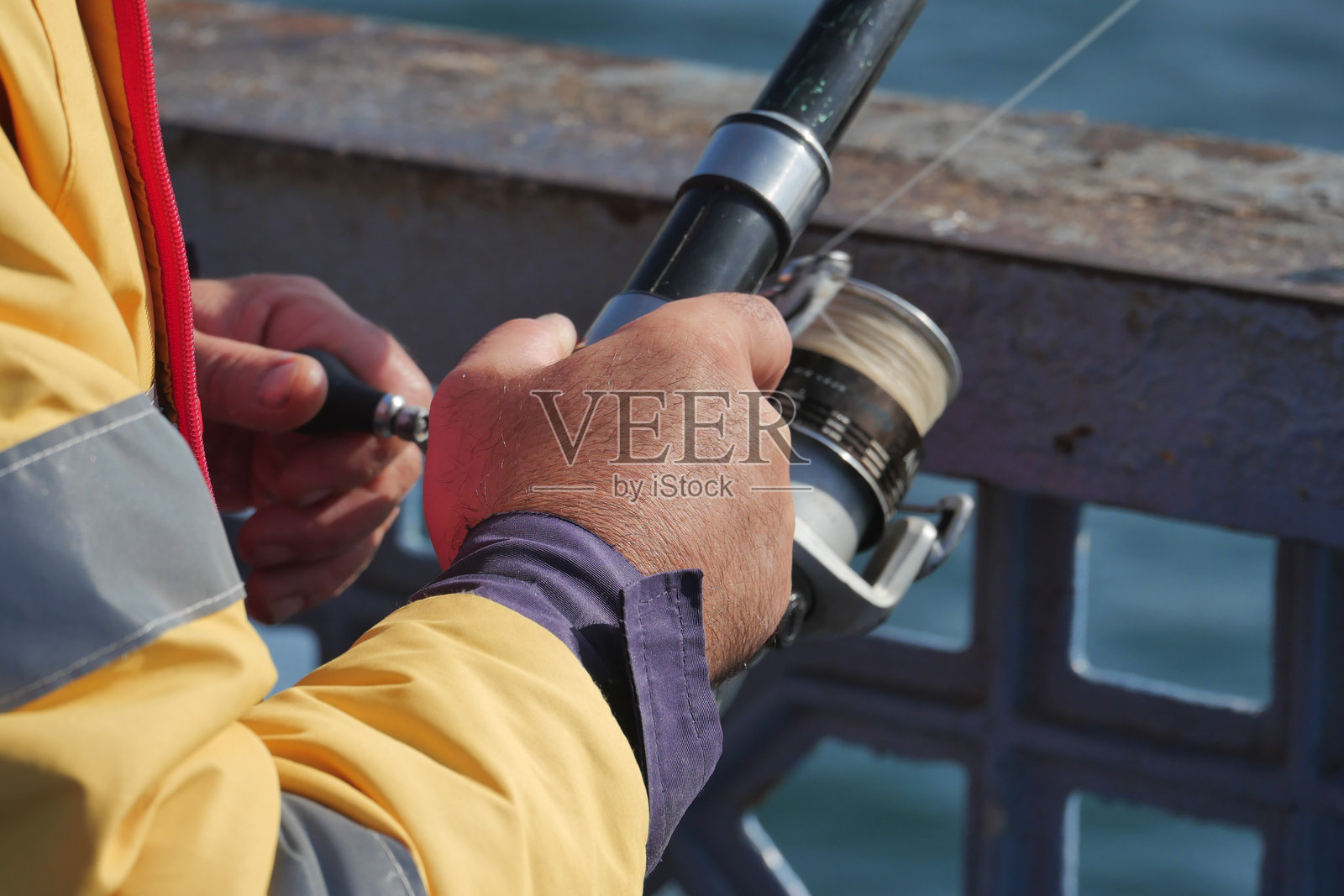 拿着钓竿和旋转卷线器的渔夫照片摄影图片