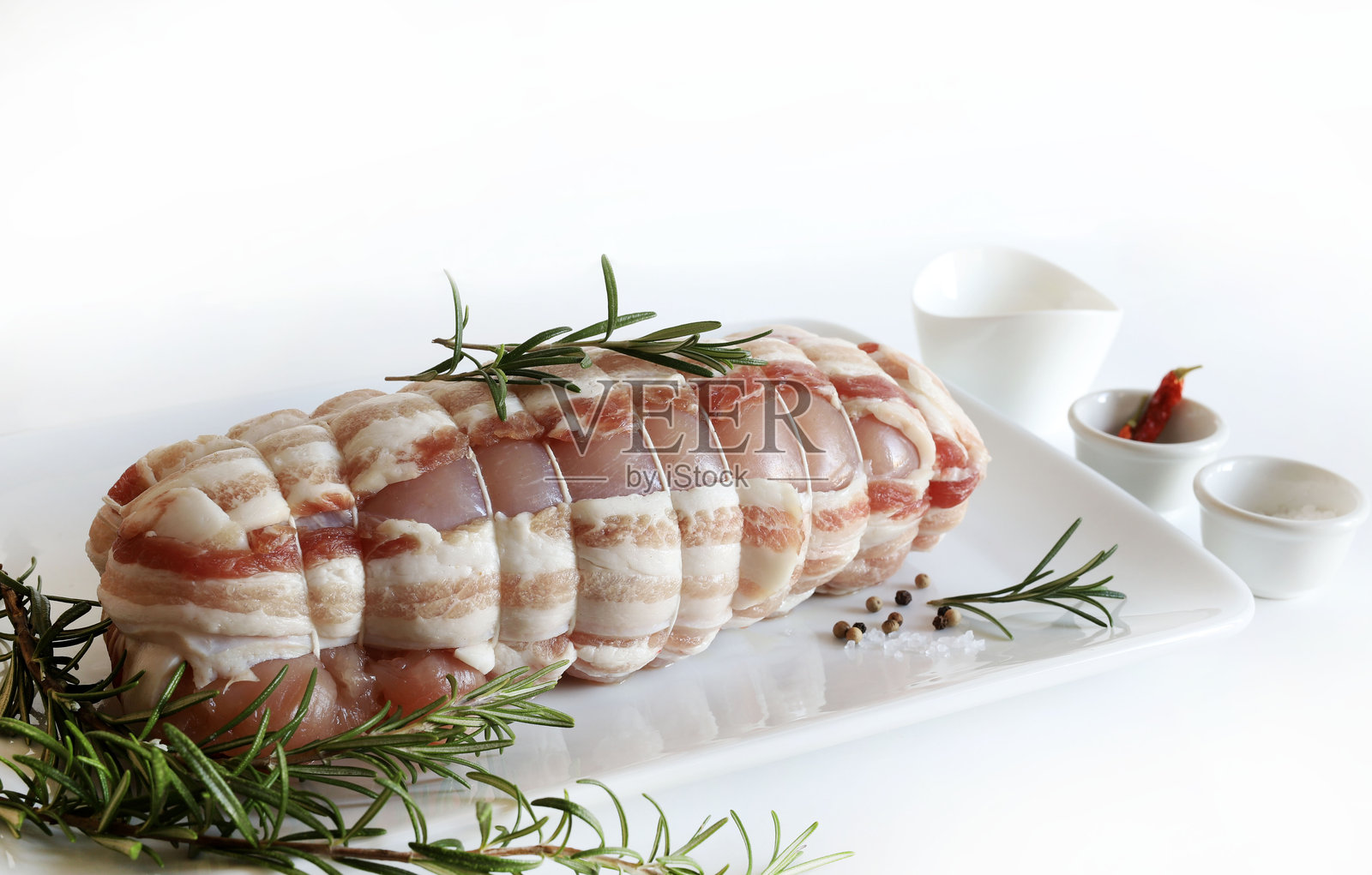 生肉卷用培根片包裹。照片摄影图片