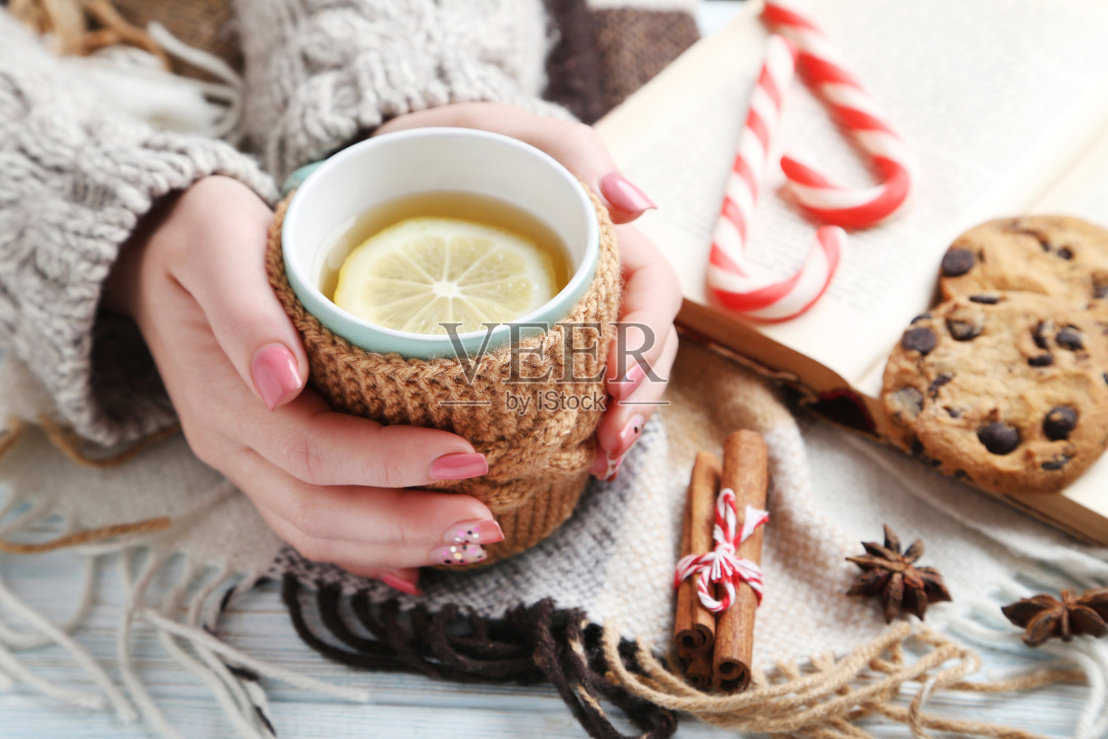 女人的手握着茶杯，放在木桌上照片摄影图片