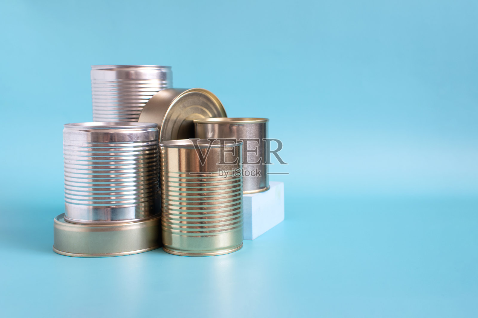 彩色背景上的各种产品特写罐头。长期储存产品。照片摄影图片