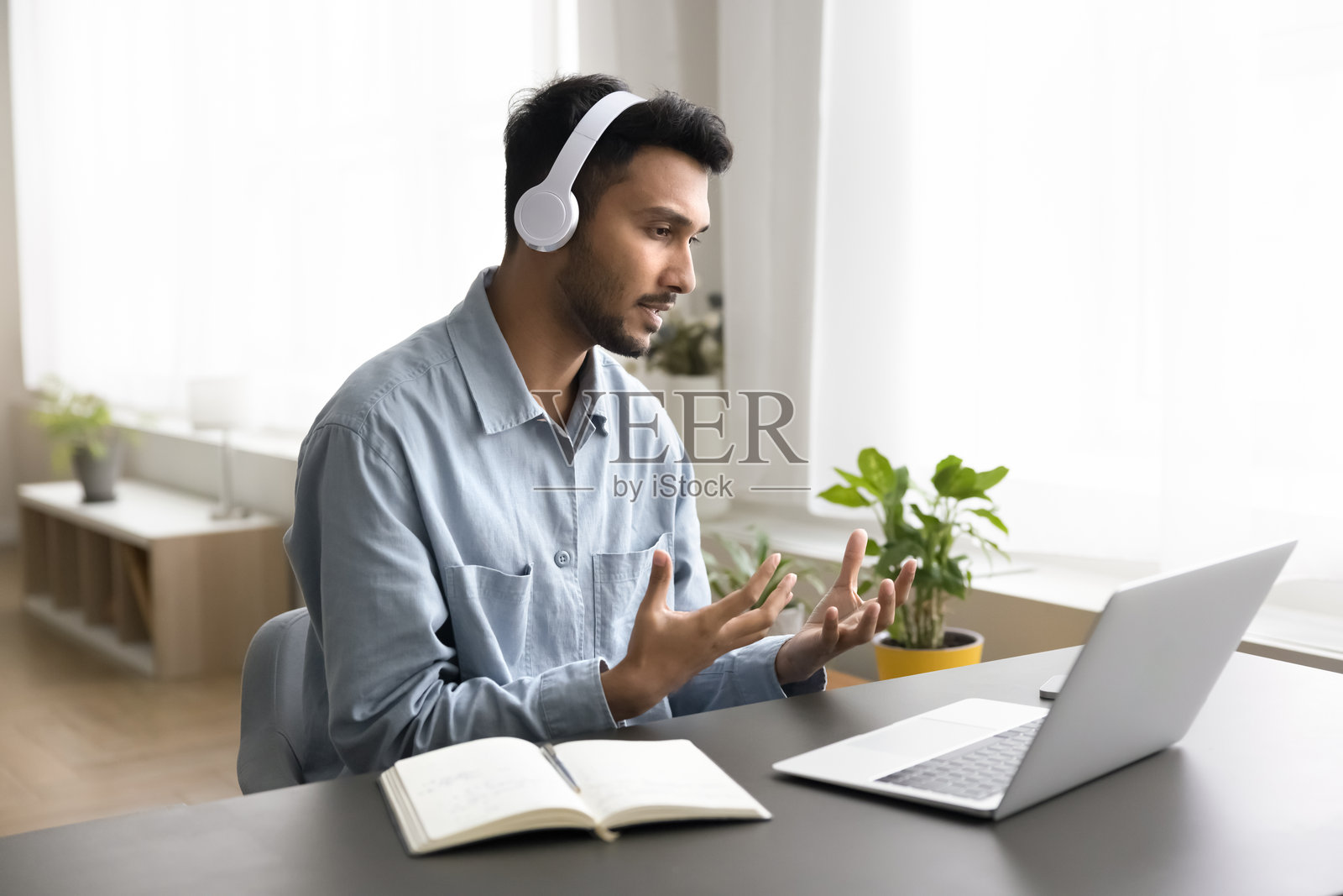 严肃的印度男子通过笔记本电脑进行在线沟通和视频通话照片摄影图片