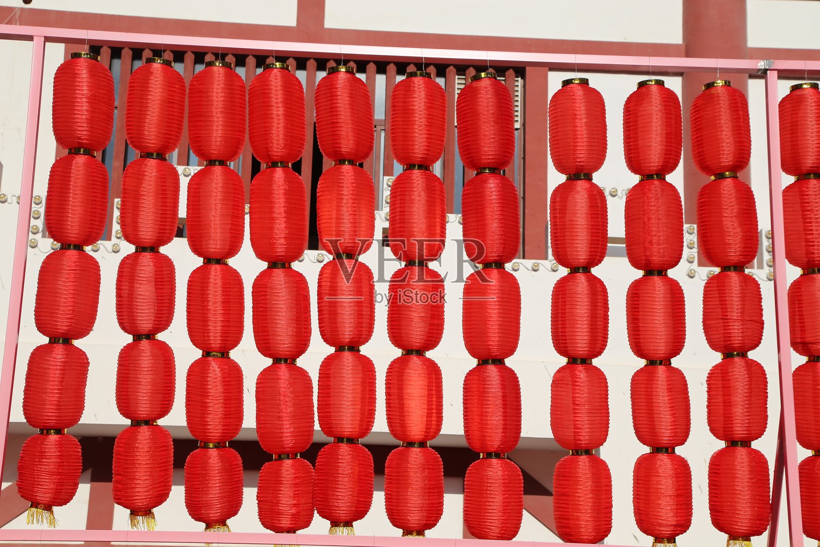 一排红色灯笼挂在围栏上，营造出浓厚的春节氛围。照片摄影图片