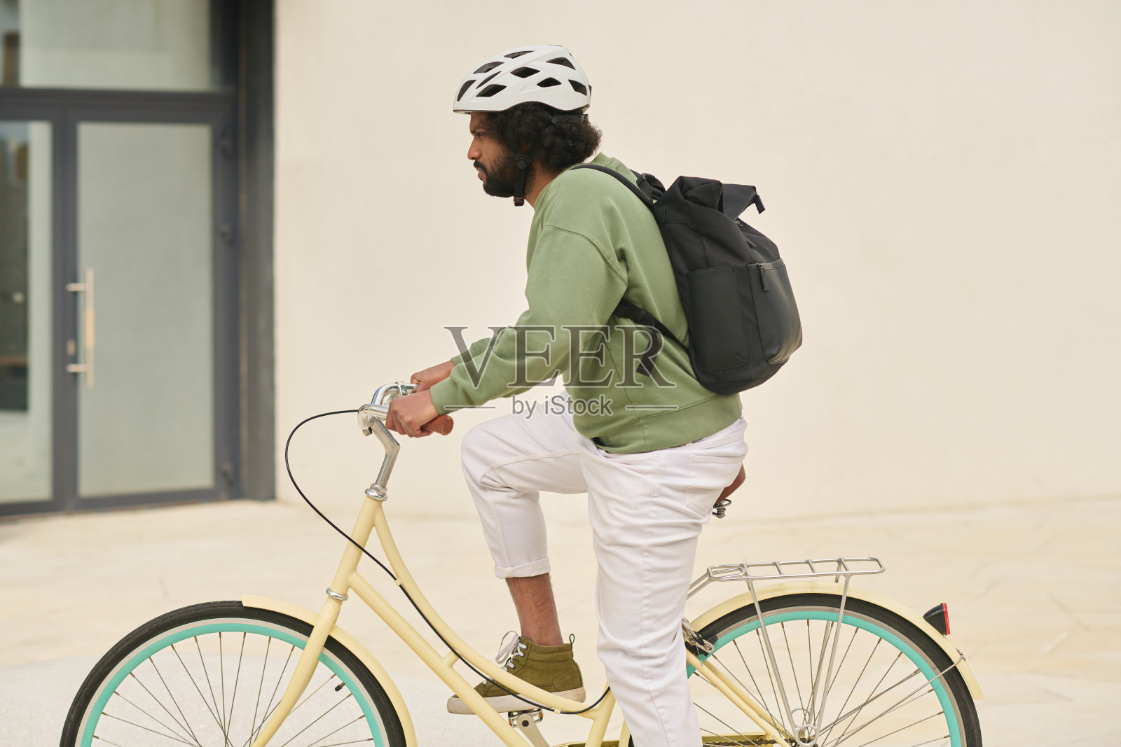 骑自行车穿过城市街道，佩戴安全头盔照片摄影图片