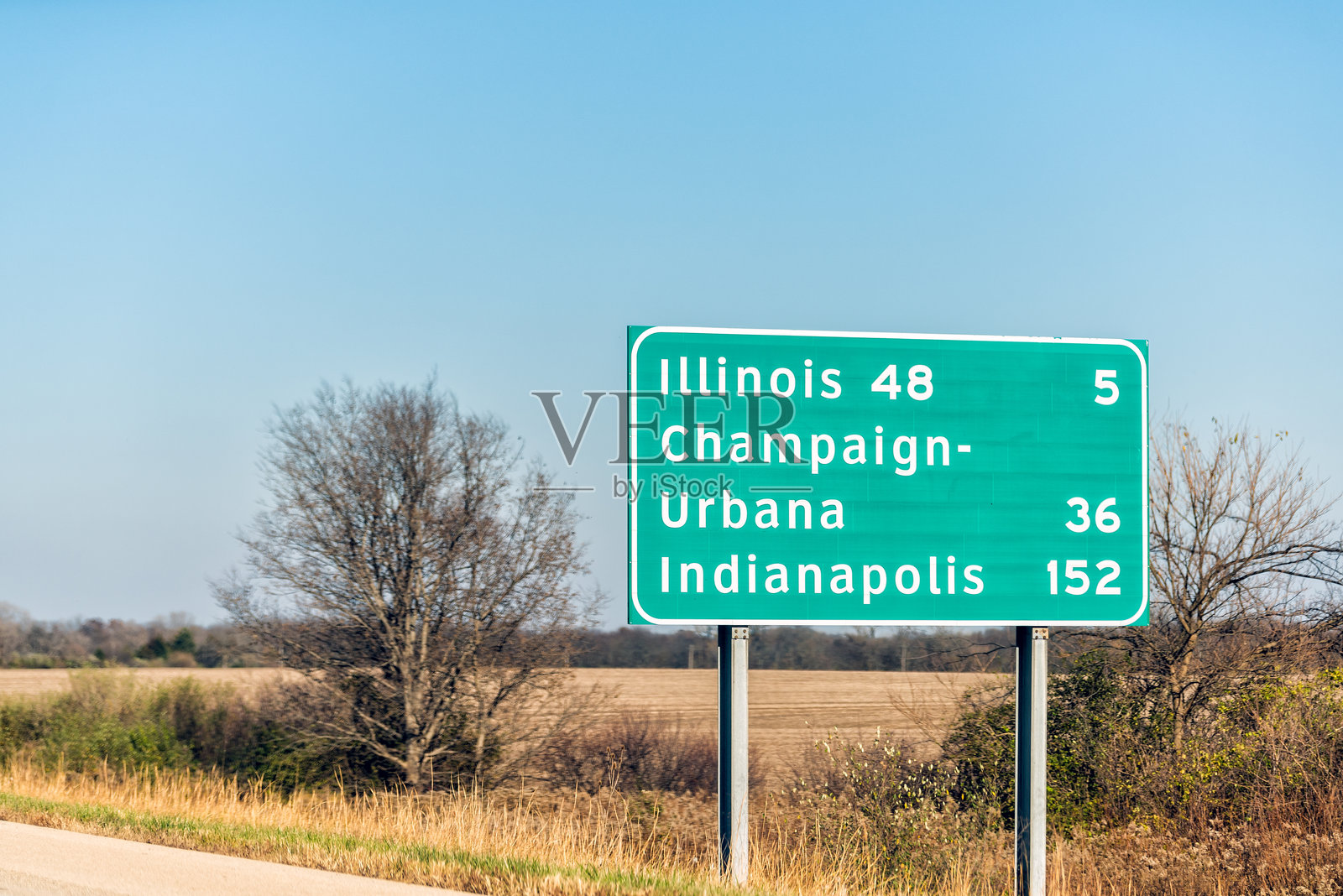 伊利诺伊州72号州际公路，路标显示到伊利诺伊州、香槟-厄巴纳和印第安纳波利斯的里程，背景是蓝天和农田。照片摄影图片