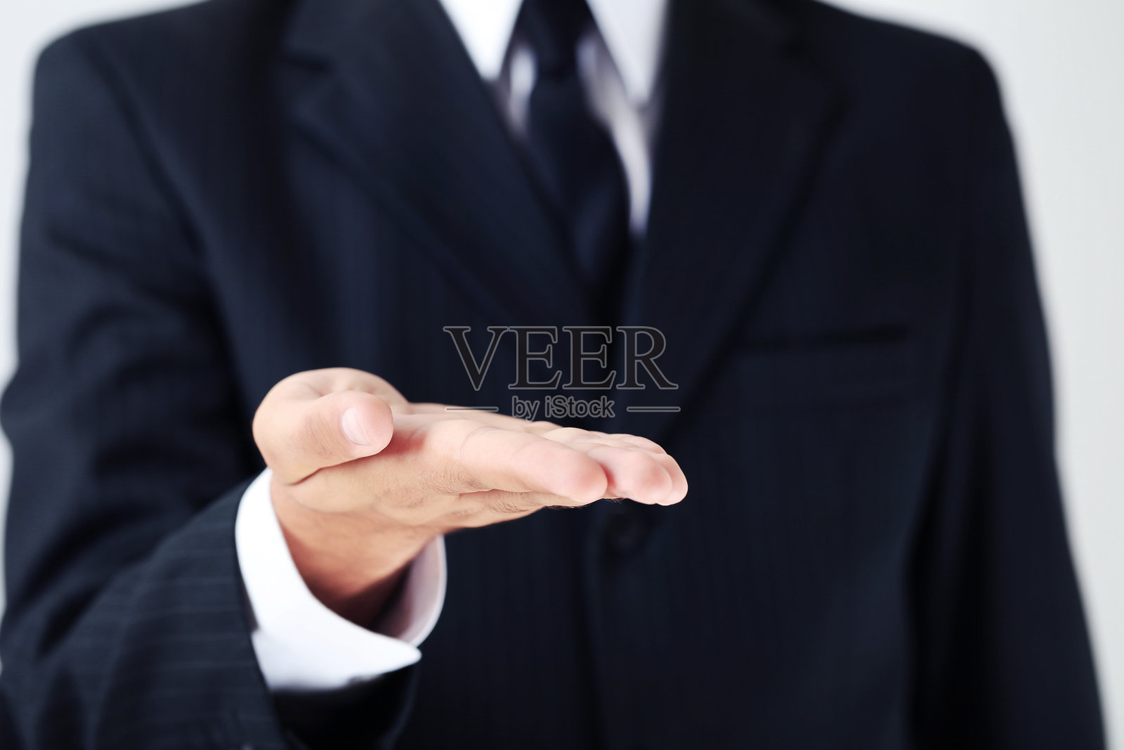 商人在灰色背景下用手势表达照片摄影图片