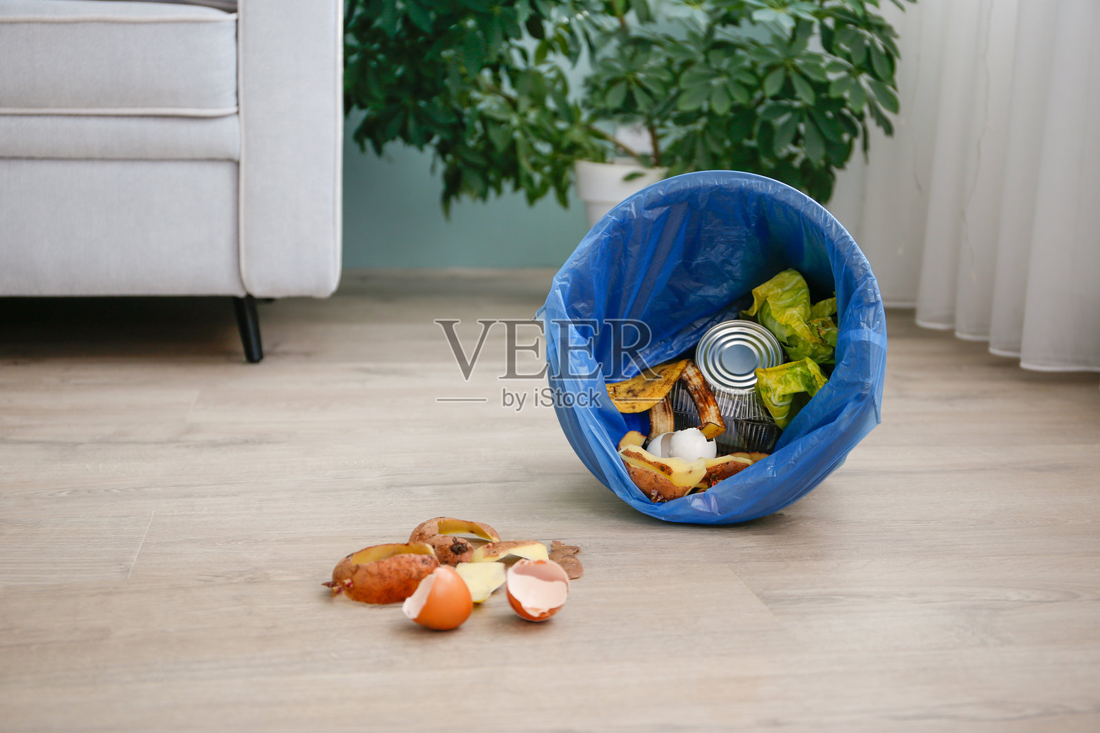 房子里地上的垃圾桶里的垃圾。照片摄影图片