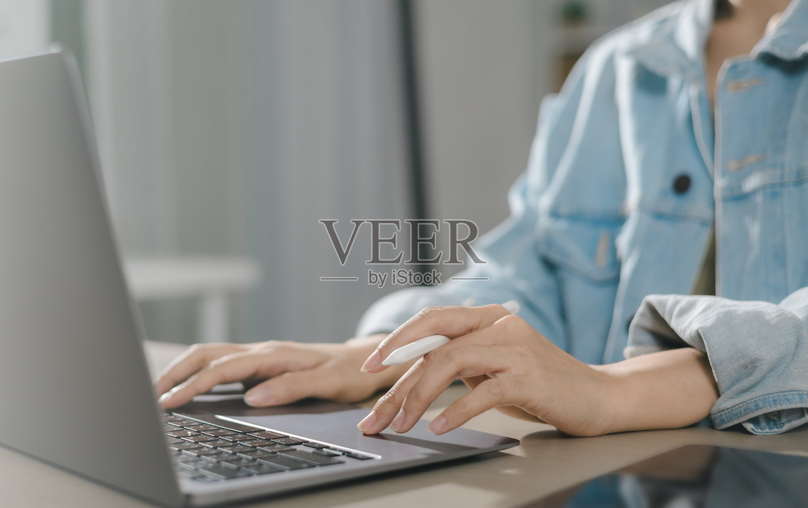 女性在家中办公室使用笔记本电脑键盘在线输入，浏览互联网搜索信息进行在线学习照片摄影图片