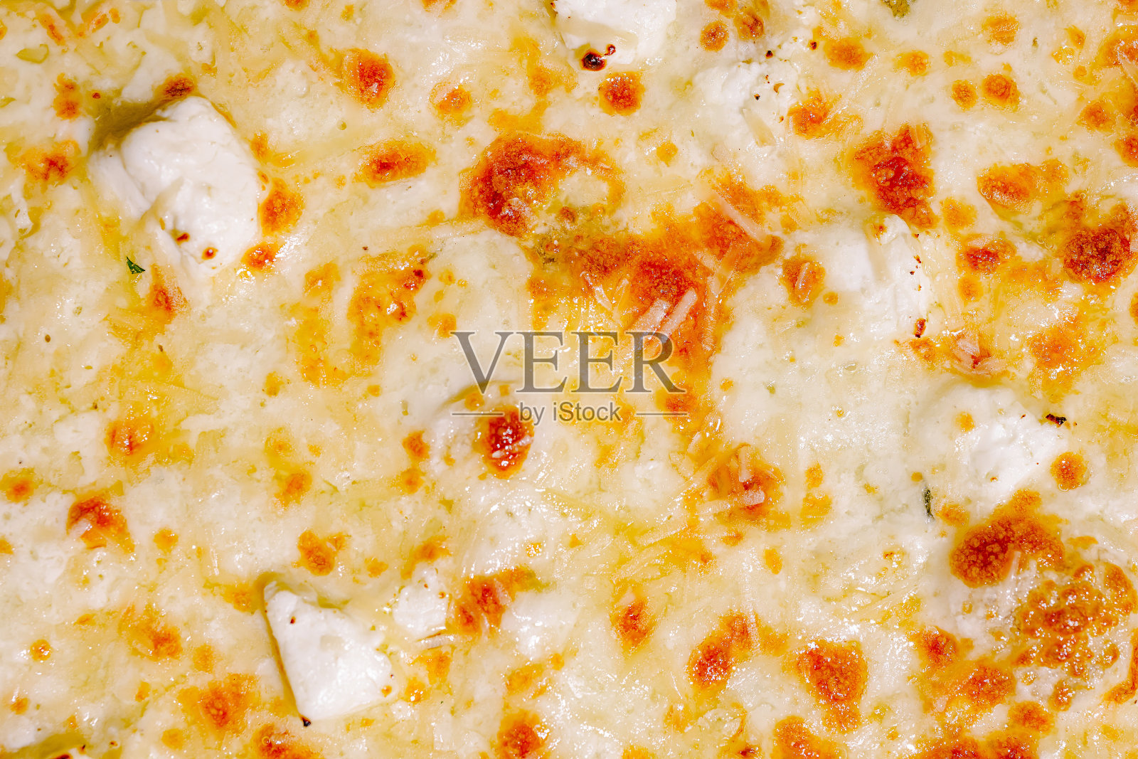 美味的金黄色融化奶酪，上面撒有香草和香料，搭配酥脆的盘子。照片摄影图片