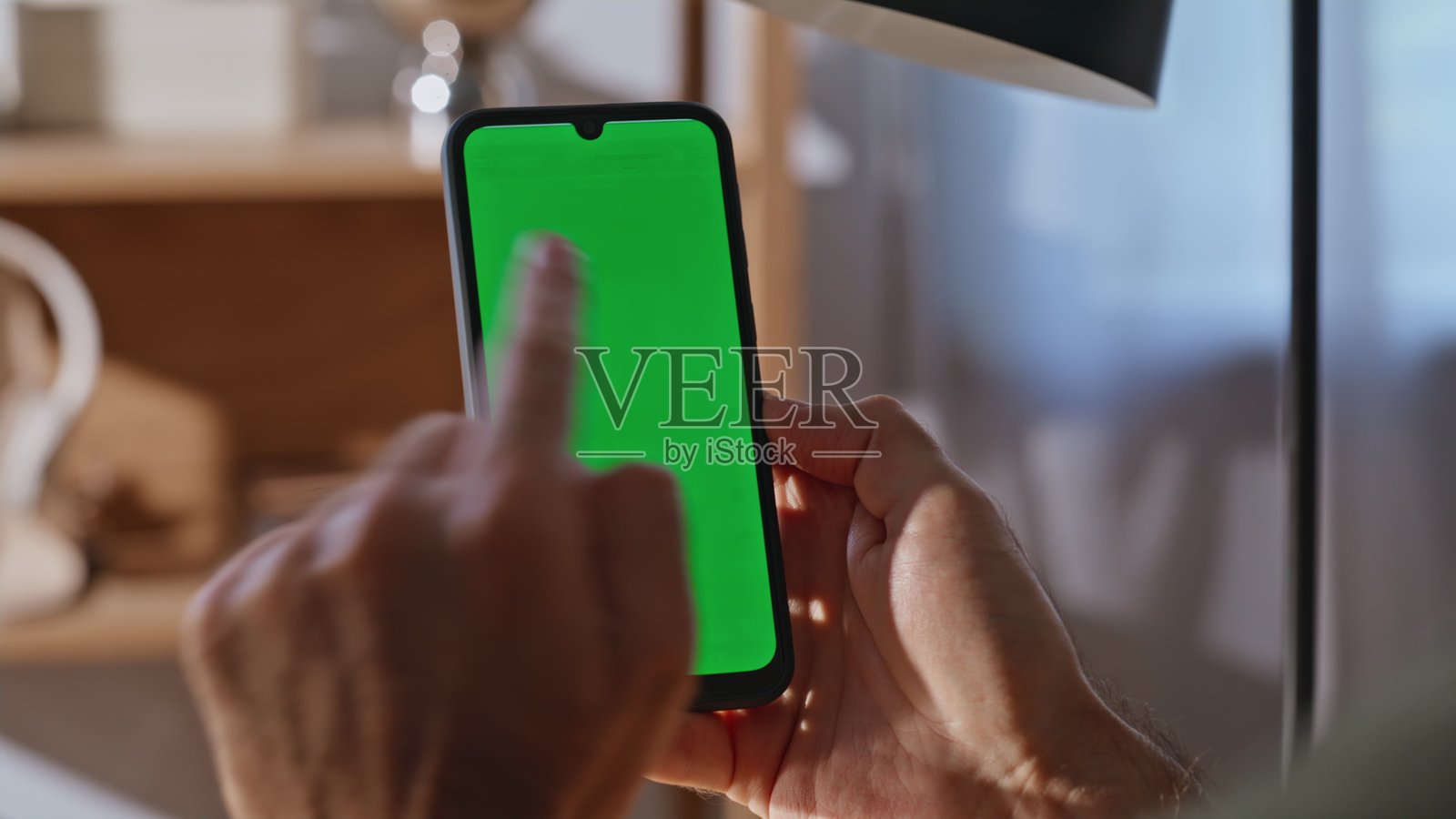 员工在工作场所近距离拍摄手机，手指轻敲设备。照片摄影图片