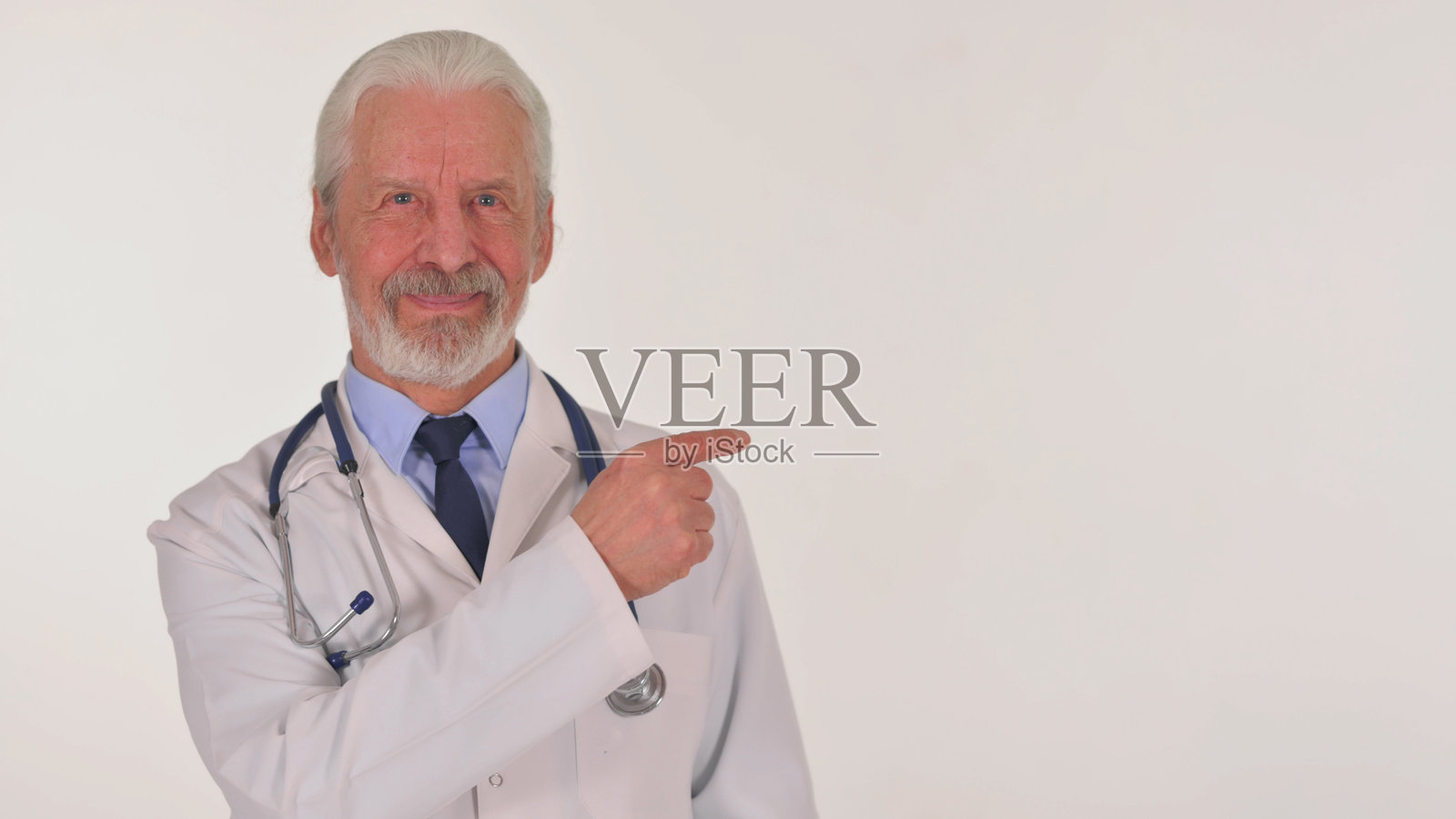 指着空白区域的老年医生肖像，背景为白色照片摄影图片