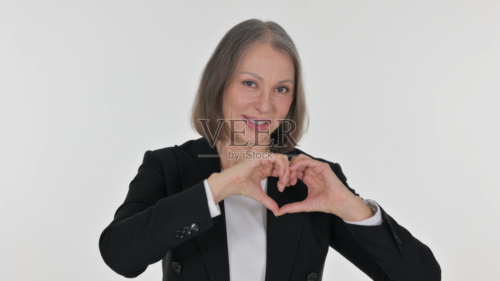 资深女商人双手做心形手势，背景为白色照片摄影图片