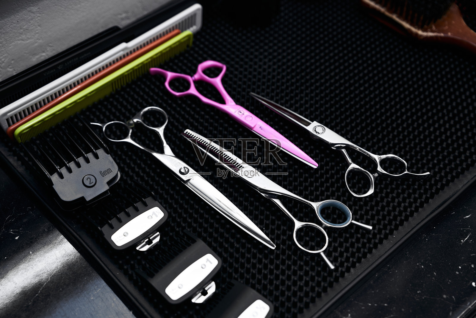 整齐排列在黑色垫子上的美发工具照片摄影图片