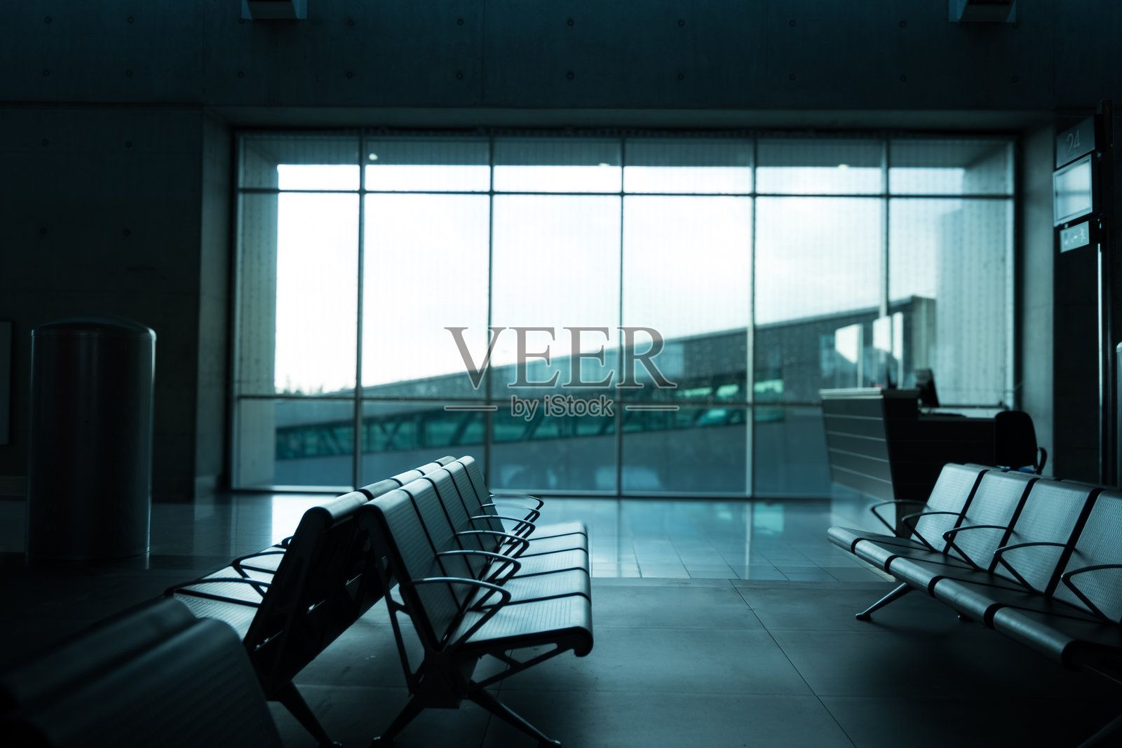 机场航站楼候机区的空座位，靠近登机口。象征着航班延误、候机室中转和现代交通枢纽舒适感的旅行概念。照片摄影图片