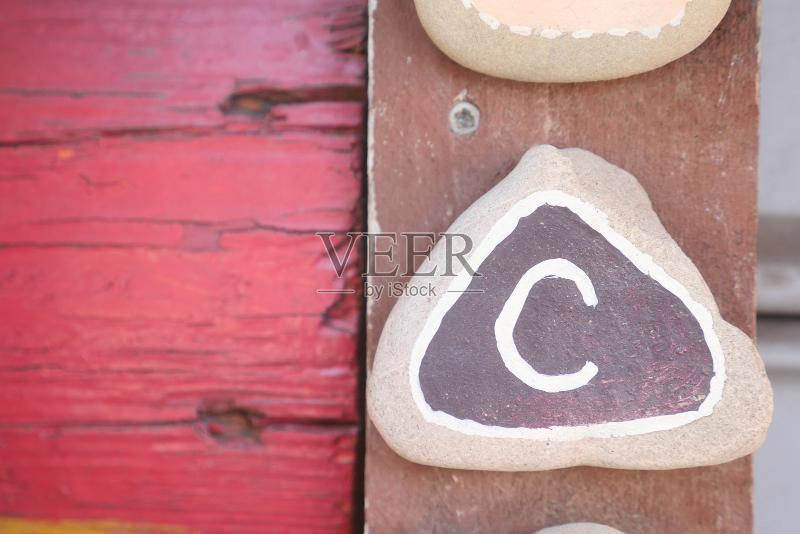 一块精美装饰的彩绘石头，上面以艺术的方式展示字母C照片摄影图片