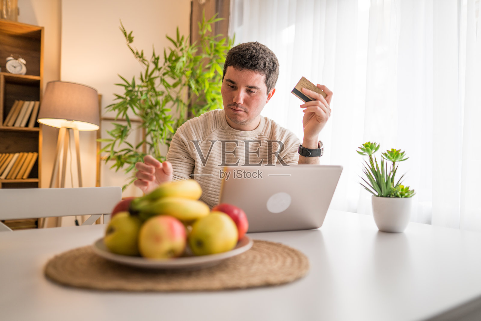 年轻男子使用笔记本电脑在线购物的肖像照片摄影图片
