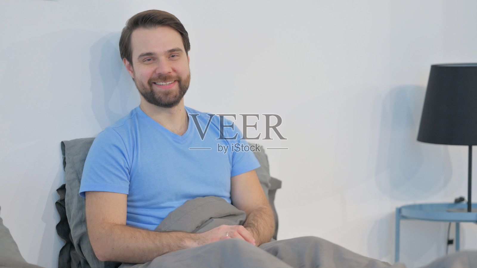 微笑的中年男子躺在床上照片摄影图片