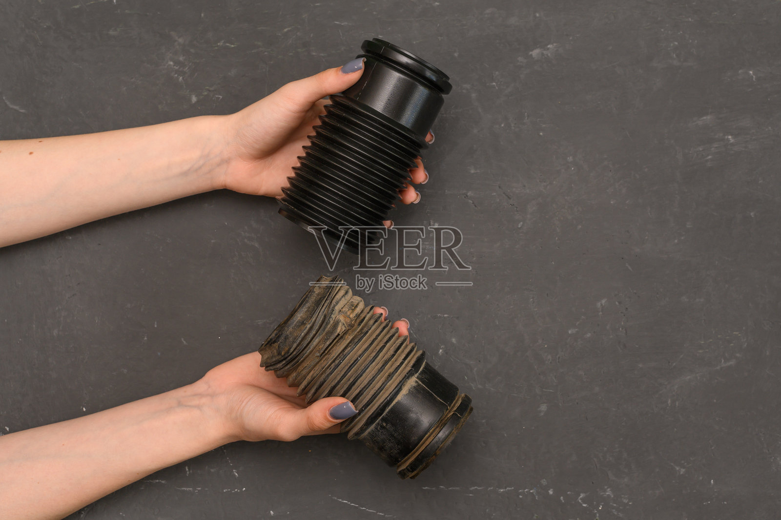 手中握着的旧磨损和新的汽车减震器保护套照片摄影图片