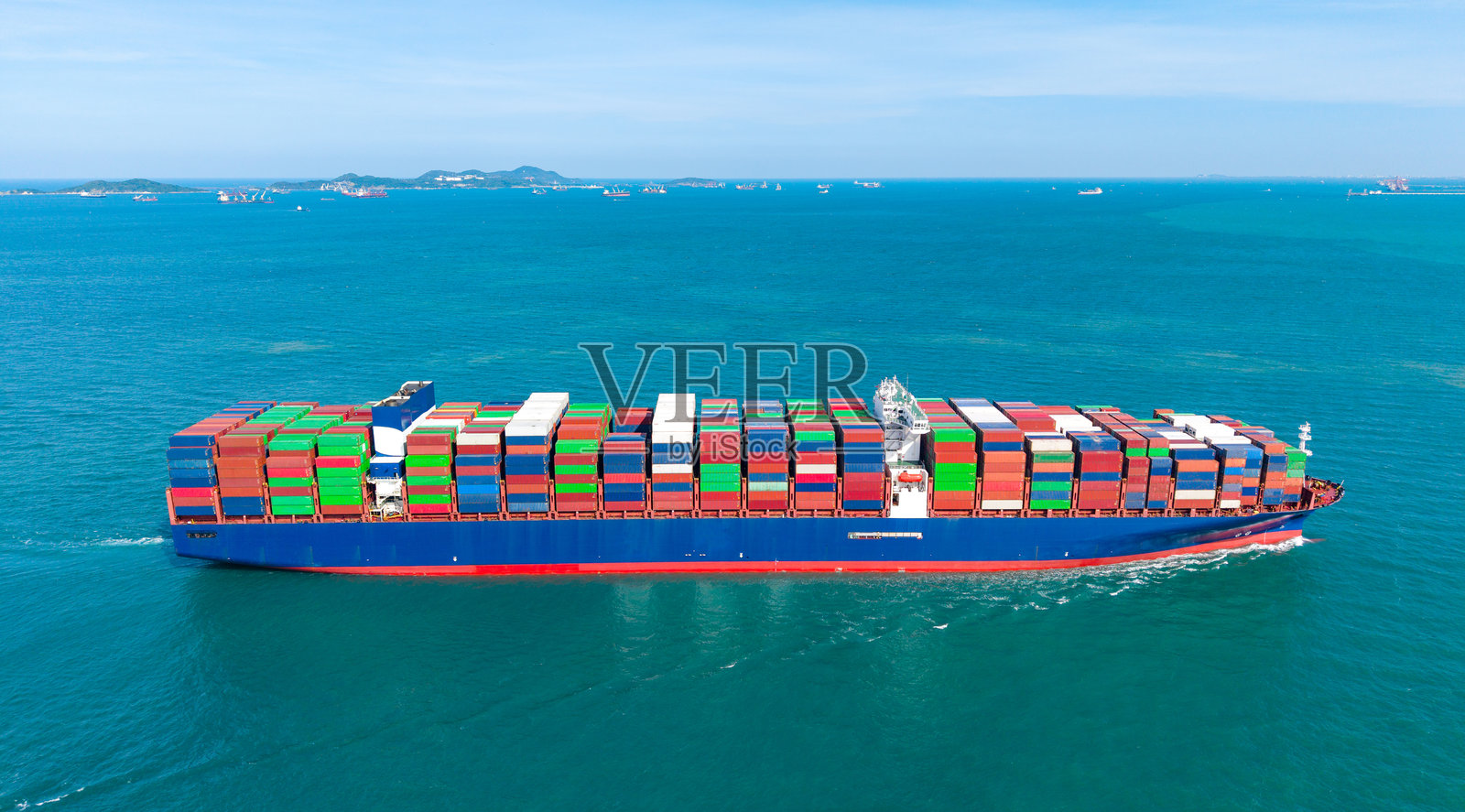 从上方看满载的集装箱船驶向港口，国际集装箱船在海港装卸货物，货运运输，航运，物流，进出口，运输。全球照片摄影图片