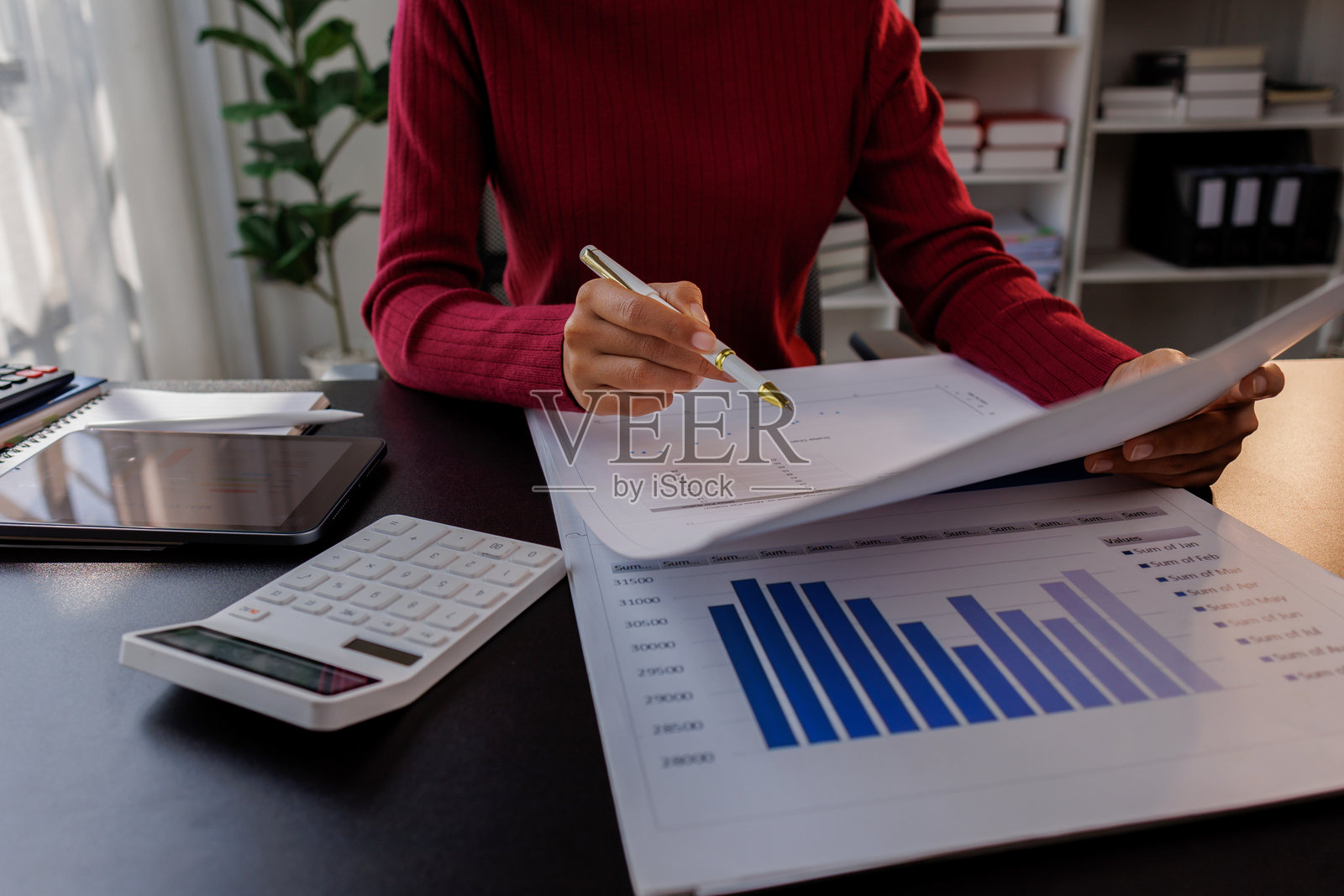 商务人士正在进行财务审计，检查计算年度财务报告、资产负债表和损益表，做笔记，核对文件和数据分析利润图表。照片摄影图片