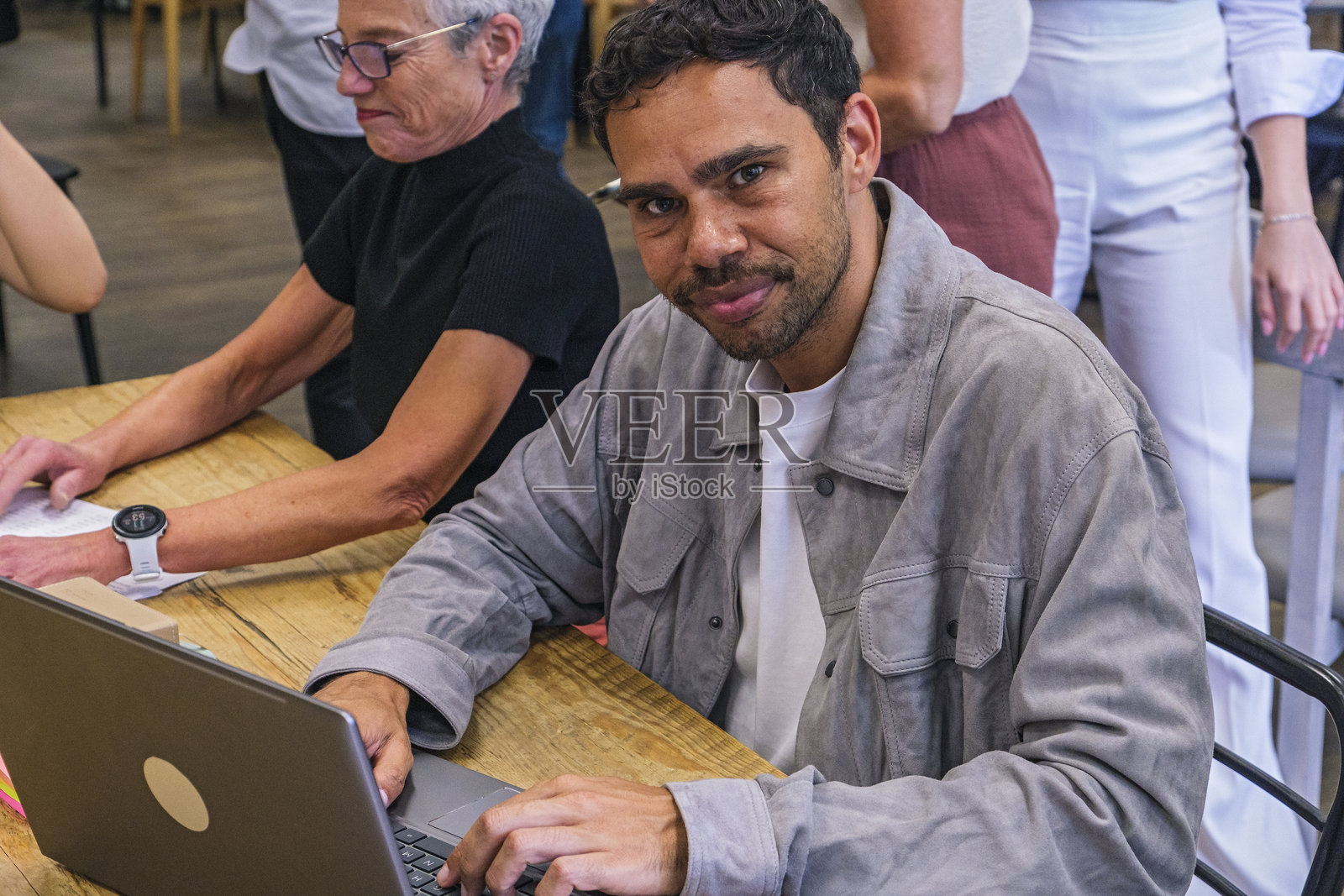 年轻的土著男性在商务会议上，抬头看向镜头照片摄影图片