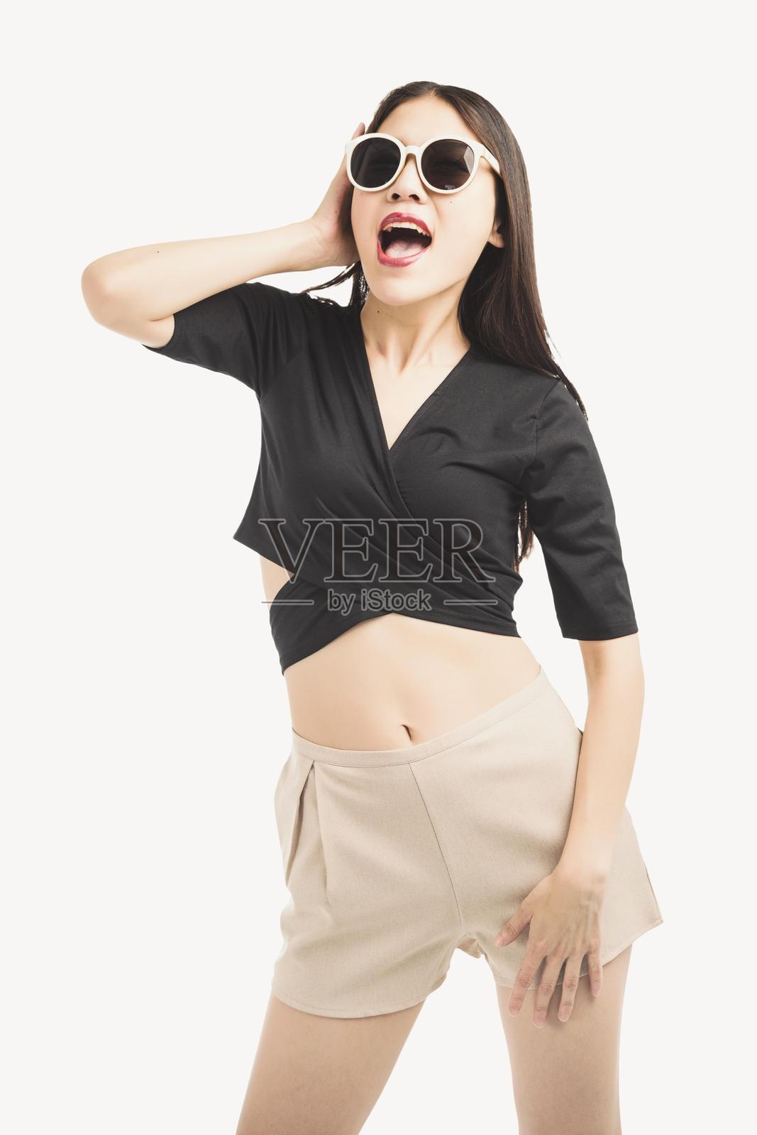 亚洲女性佩戴太阳镜，穿着米色短裤照片摄影图片