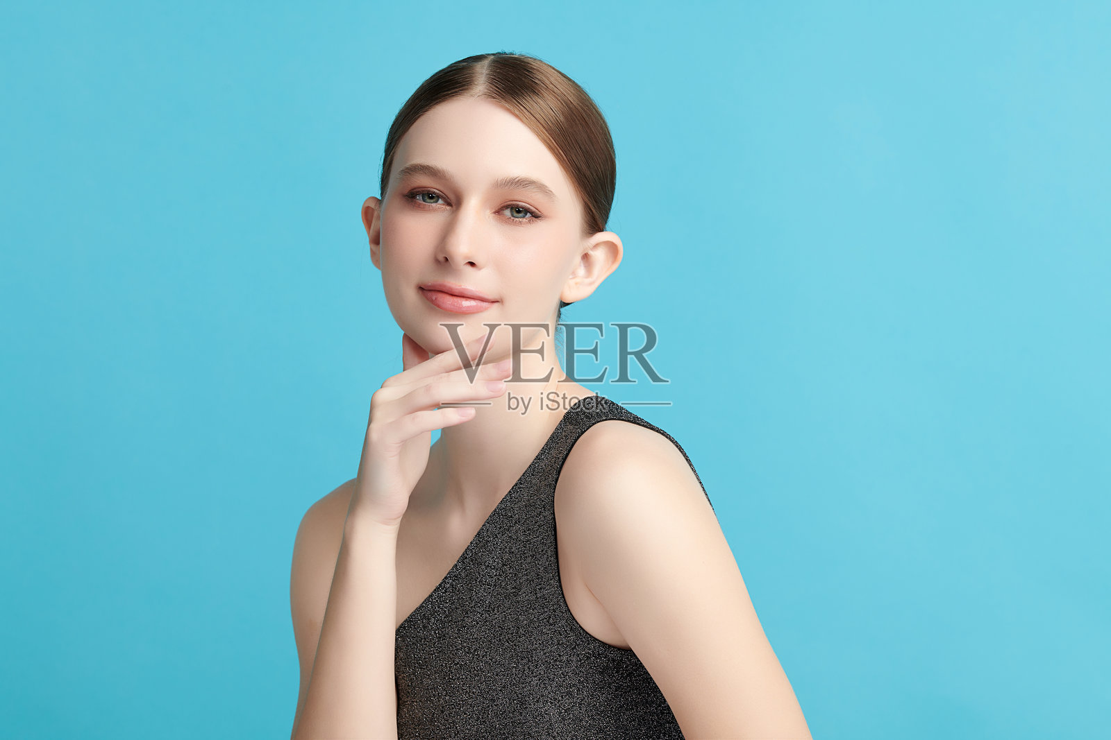 美丽的年轻女性，肤色洁净清新，背景为蓝色，面部护理，面部治疗，美容学，美容与水疗，女性肖像。照片摄影图片