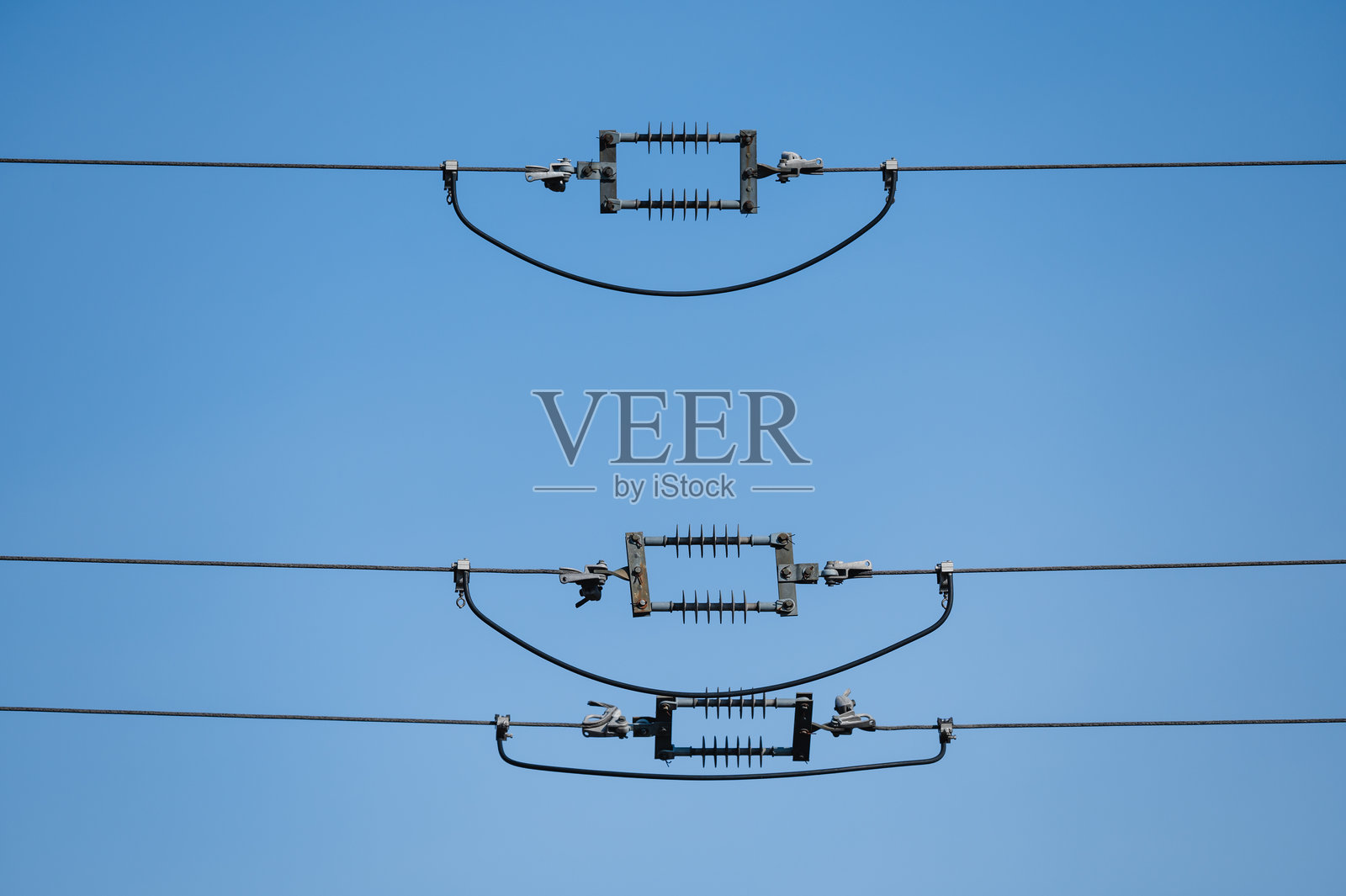 高压电力线与蓝天中的绝缘子照片摄影图片