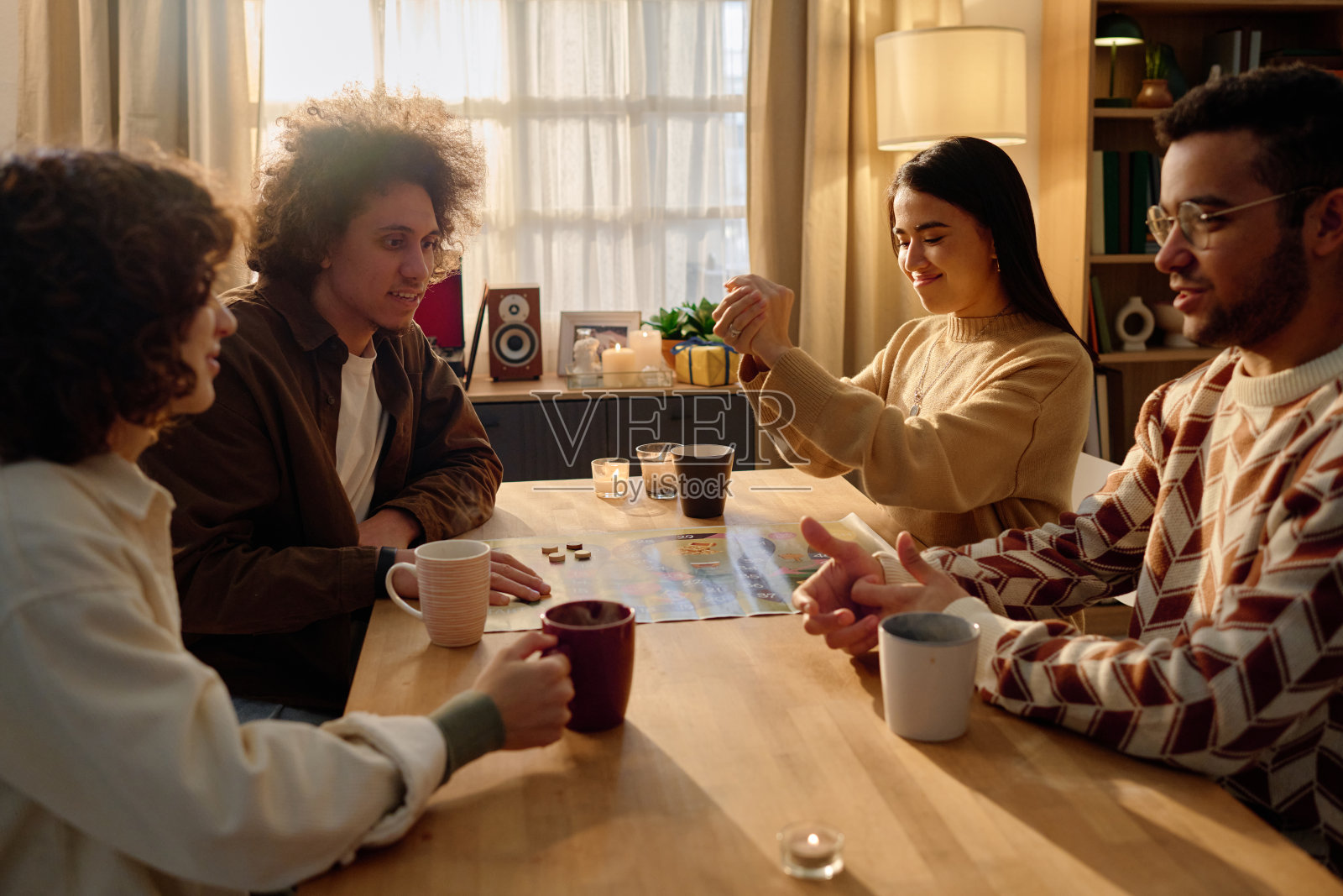 朋友们喝着草药茶，玩着桌游照片摄影图片