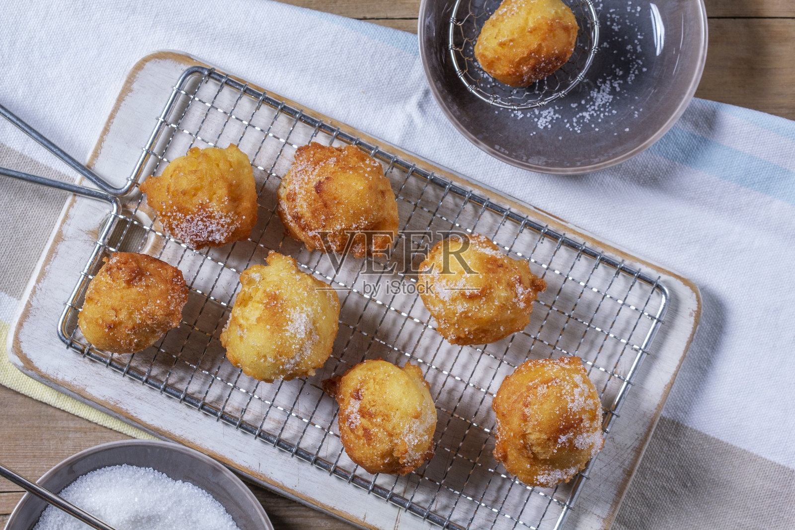 奶酪甜甜圈撒上糖，搭配茶或咖啡，背景为浅色木质桌面。乡村风格。照片摄影图片