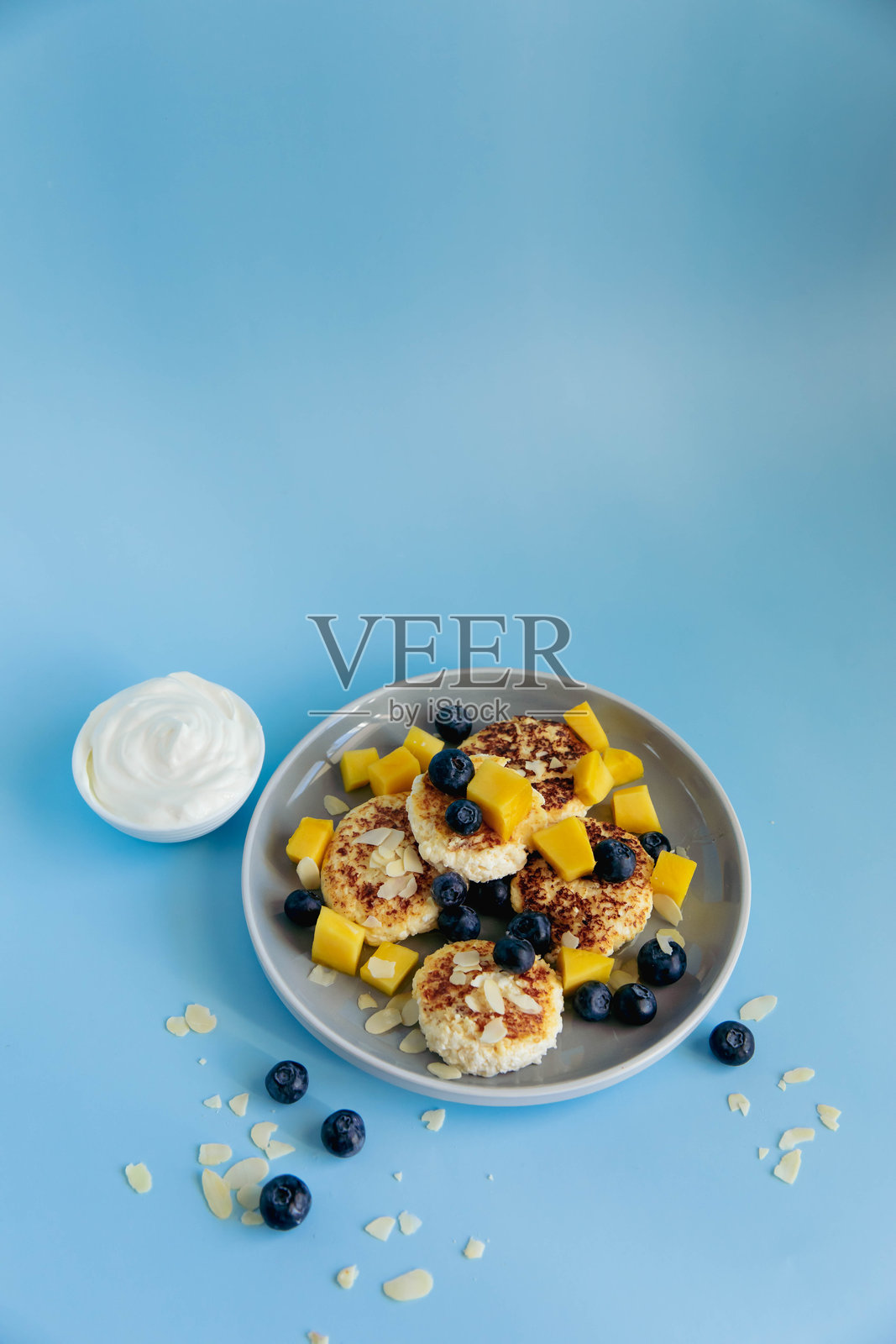 蓝色背景上的奶酪蛋糕和浆果早餐照片摄影图片
