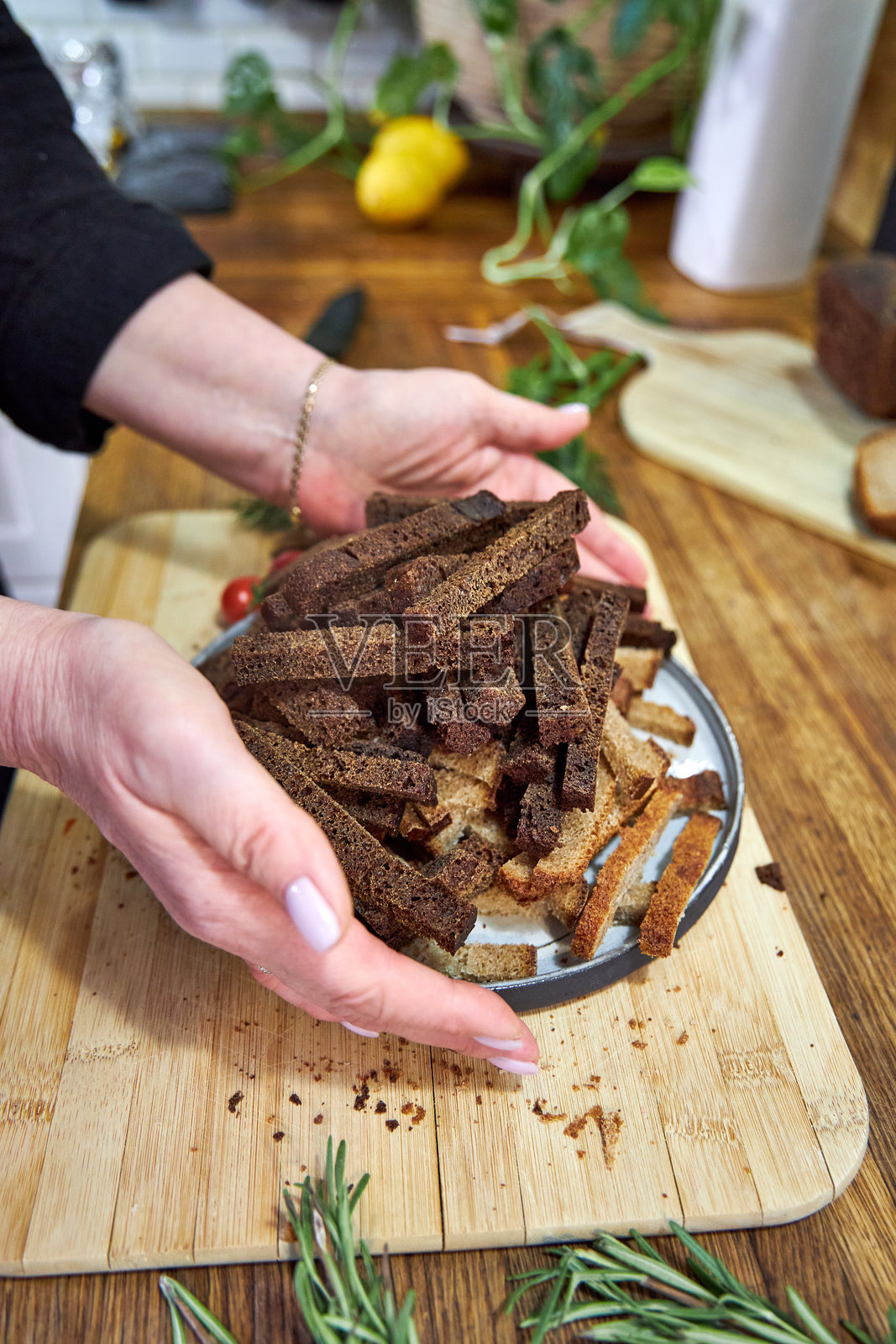 从上方看，女人手里拿着一盘黑麦面包屑照片摄影图片