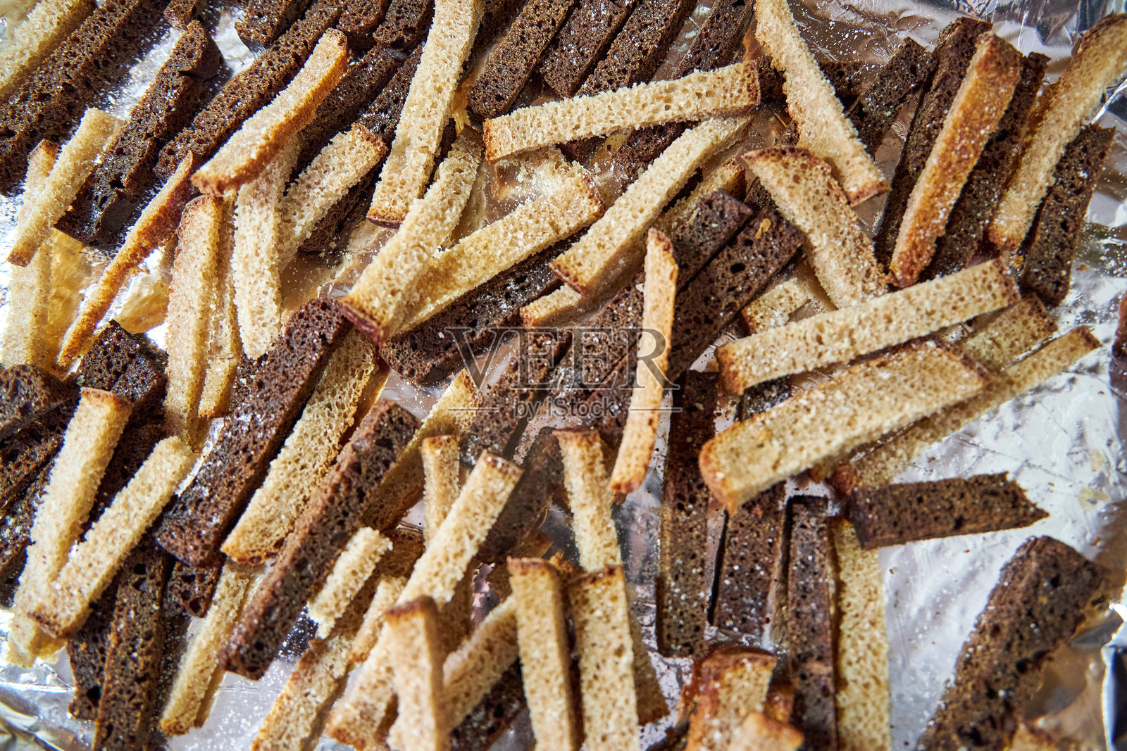 托盘上放着灰色和黑色面包的切片，用于制作面包屑。照片摄影图片