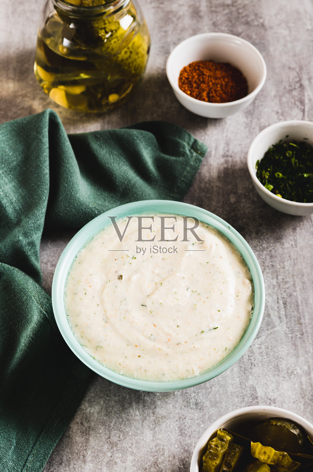 碗里盛着带有大蒜的辛辣酸奶油酱，桌子上的垂直视角照片摄影图片