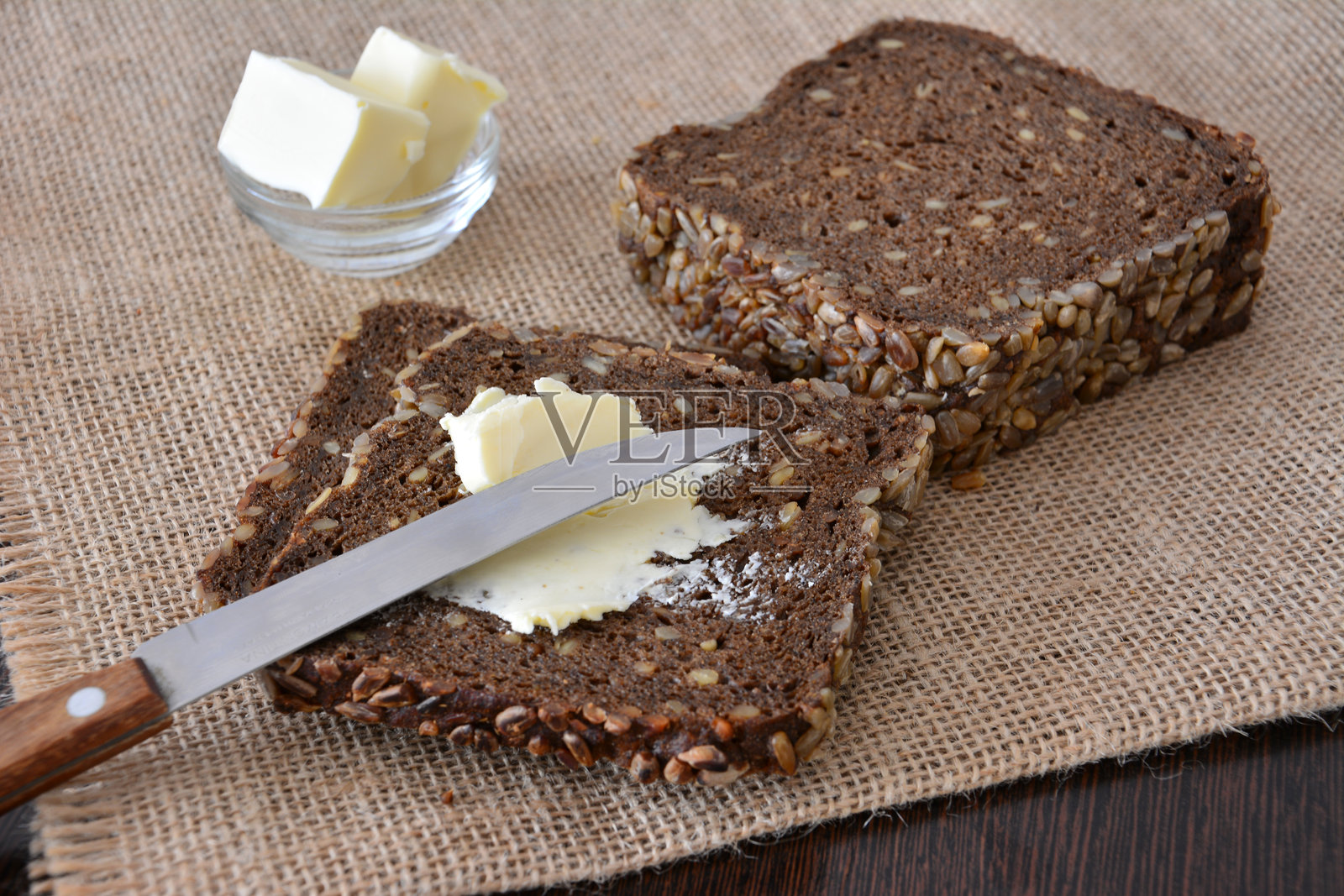 切片黑麦面包配黄油和黄油刀照片摄影图片