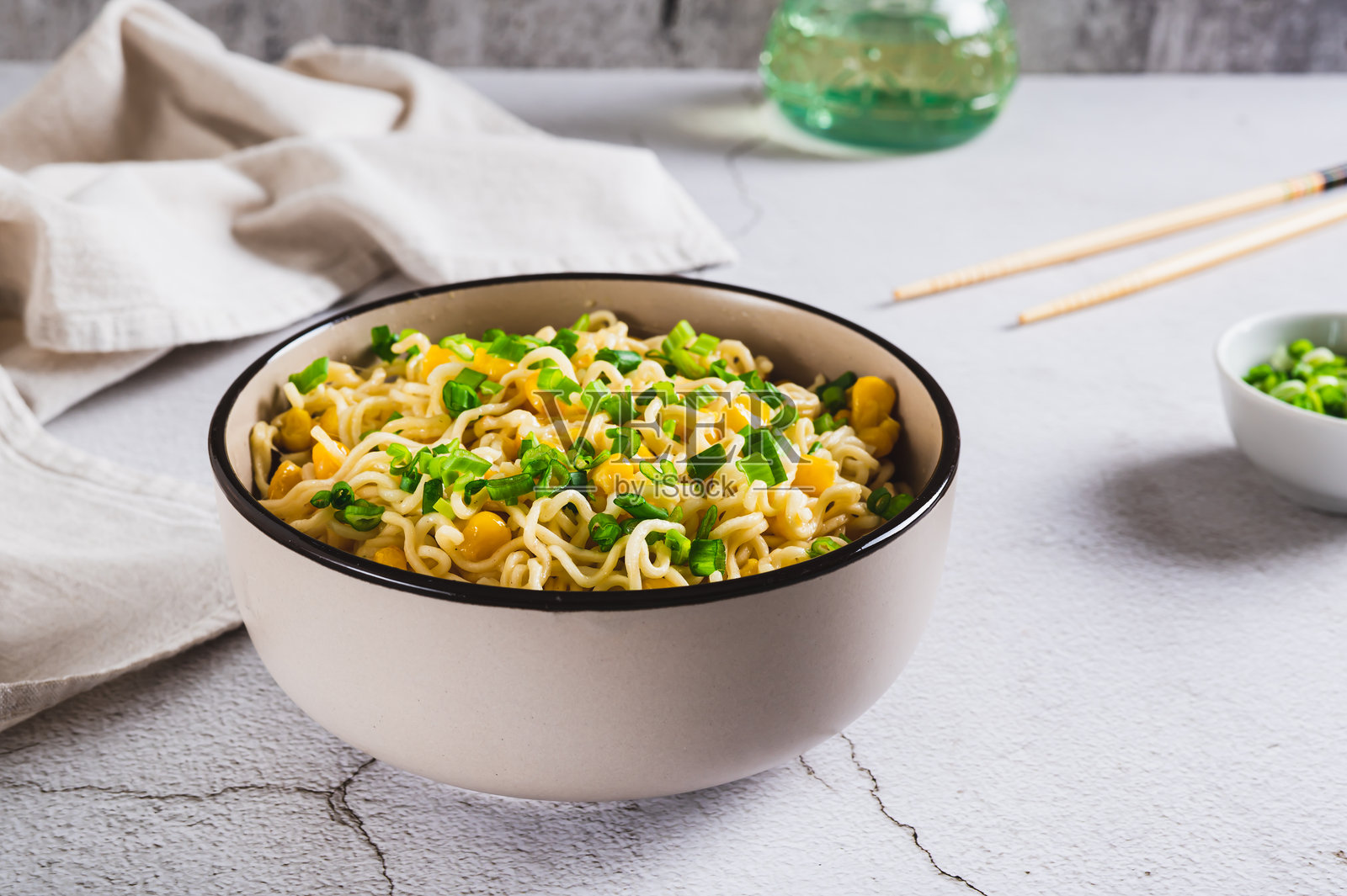 碗里盛着玉米和葱花的方便面放在桌子上照片摄影图片