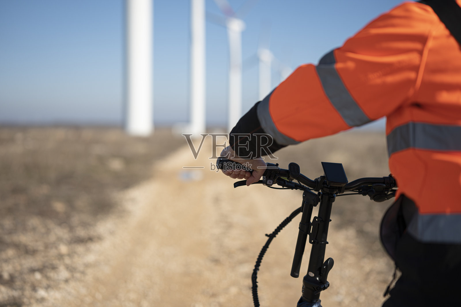 可持续发展与生态通勤视角。风能工程师骑电动自行车，配备自行车电脑。照片摄影图片