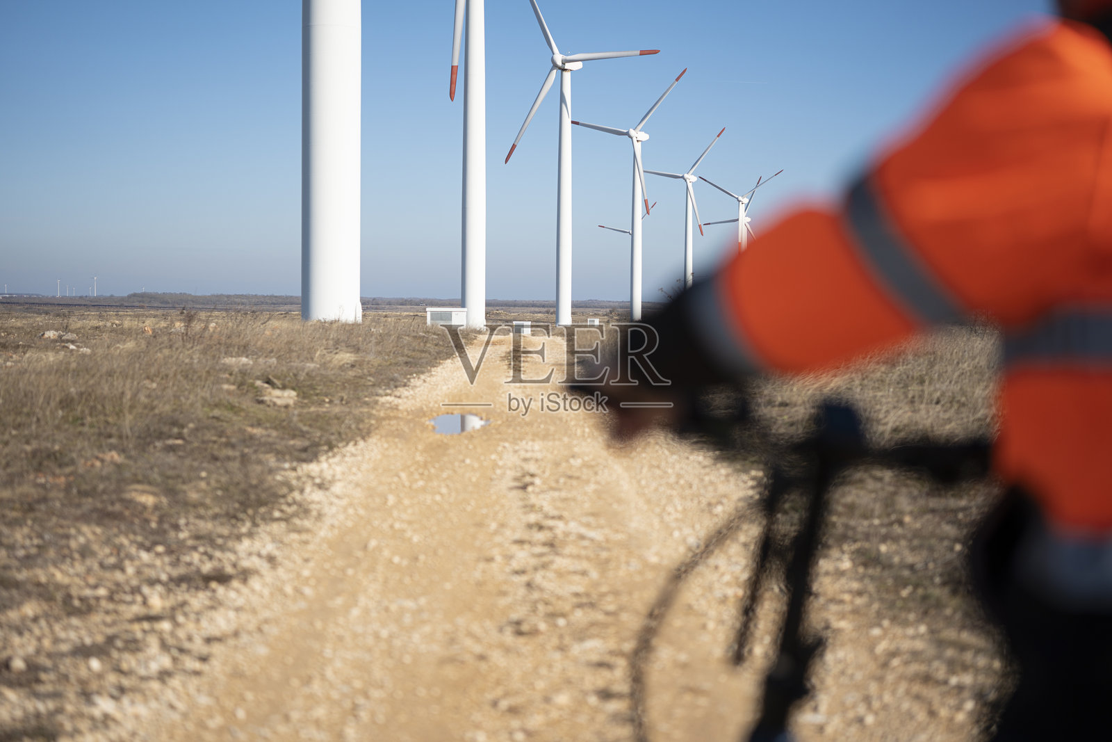 可持续发展与环保通勤视角。风能工程师骑电动自行车，配备自行车电脑。照片摄影图片