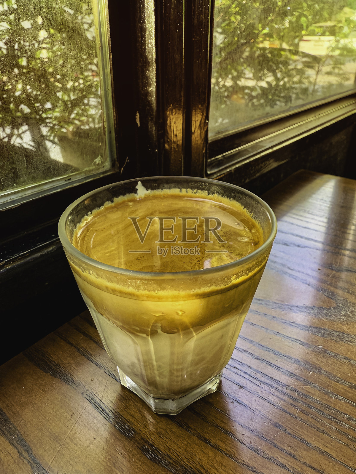 玻璃杯中的牛奶咖啡，热饮，放在木板上照片摄影图片