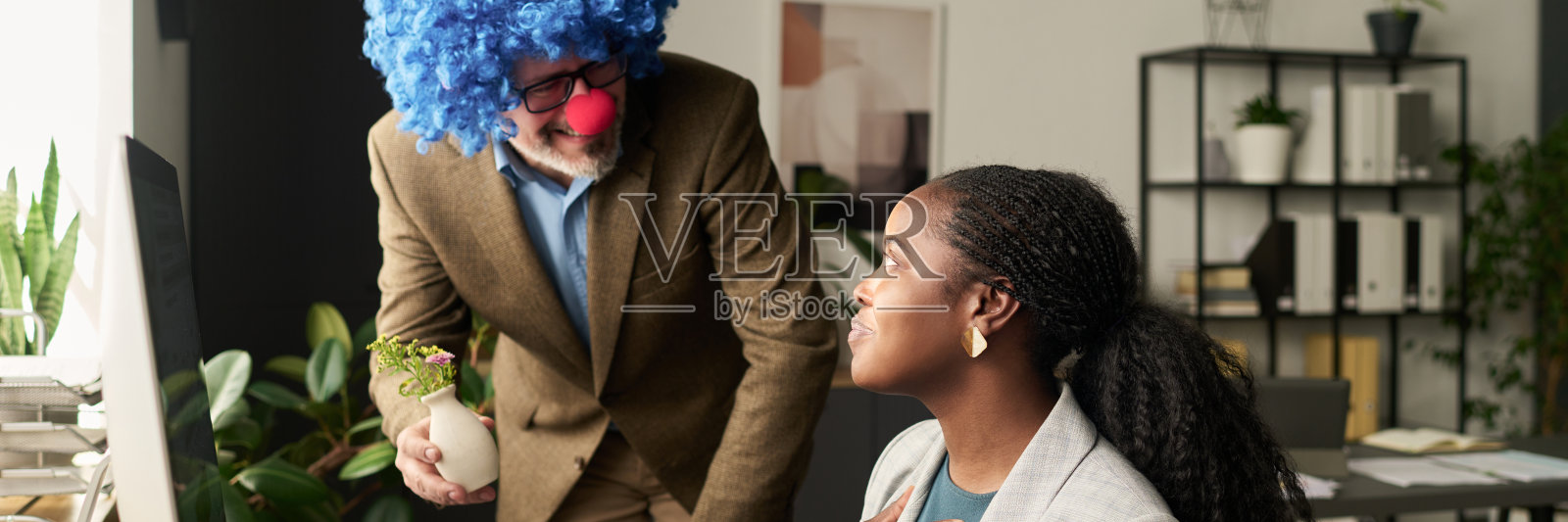 小丑老板给下属送礼照片摄影图片